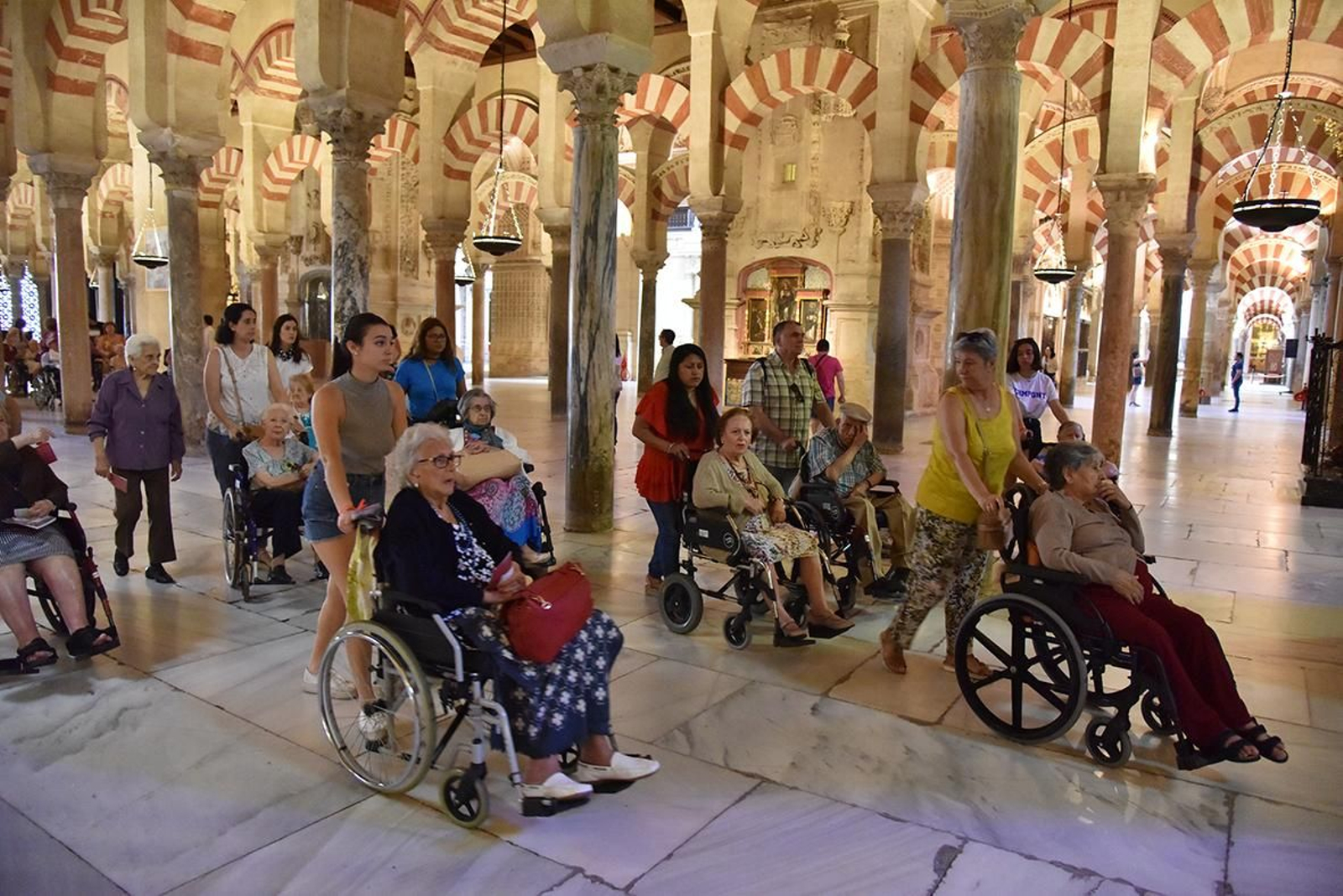 Varias personas en sillas de ruedas visitan la Mezquita-Catedral.