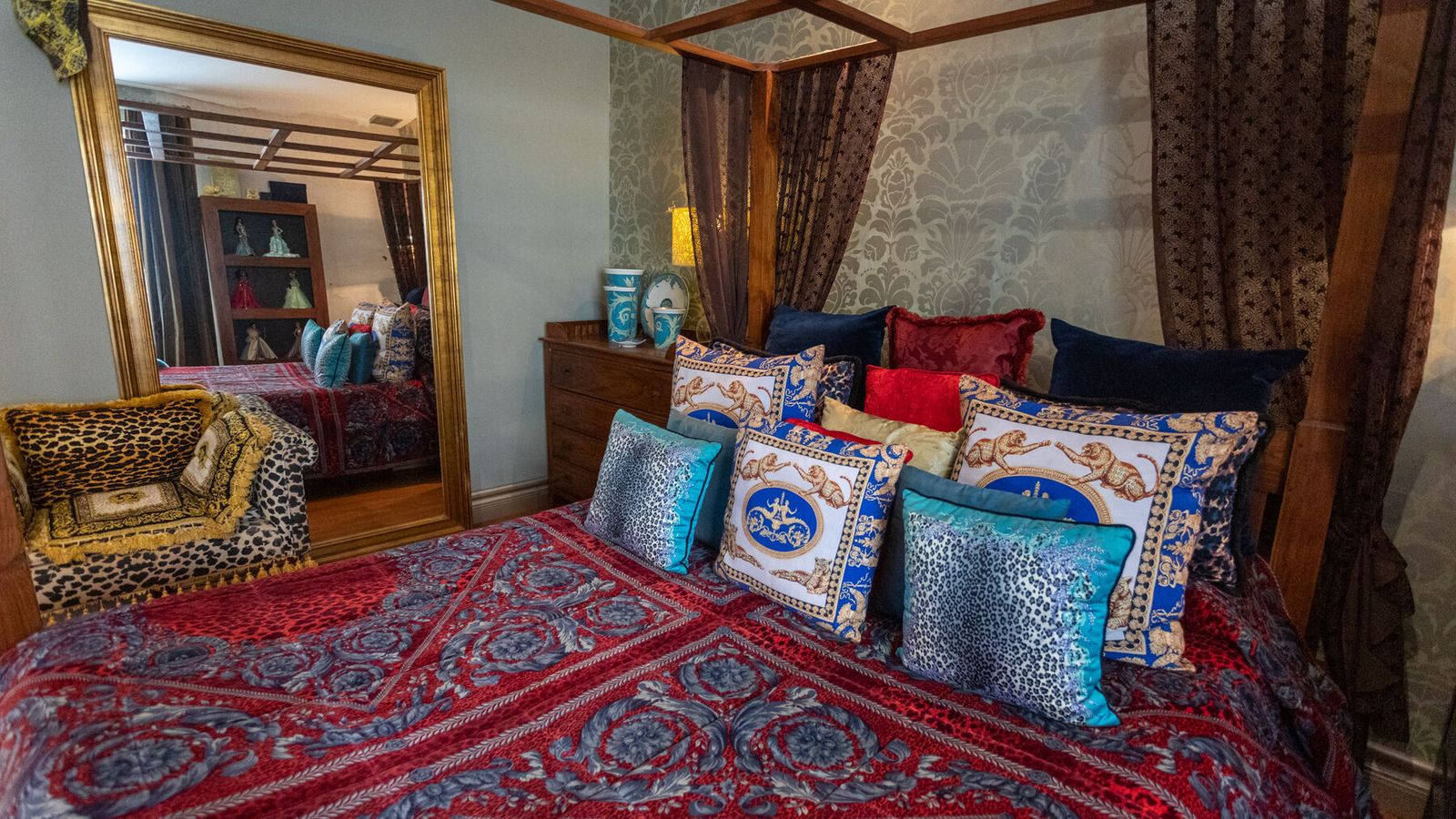 Dormitorio. Cama con dosel con cortinas de gasa devoré y edredón y cojines de Versace.