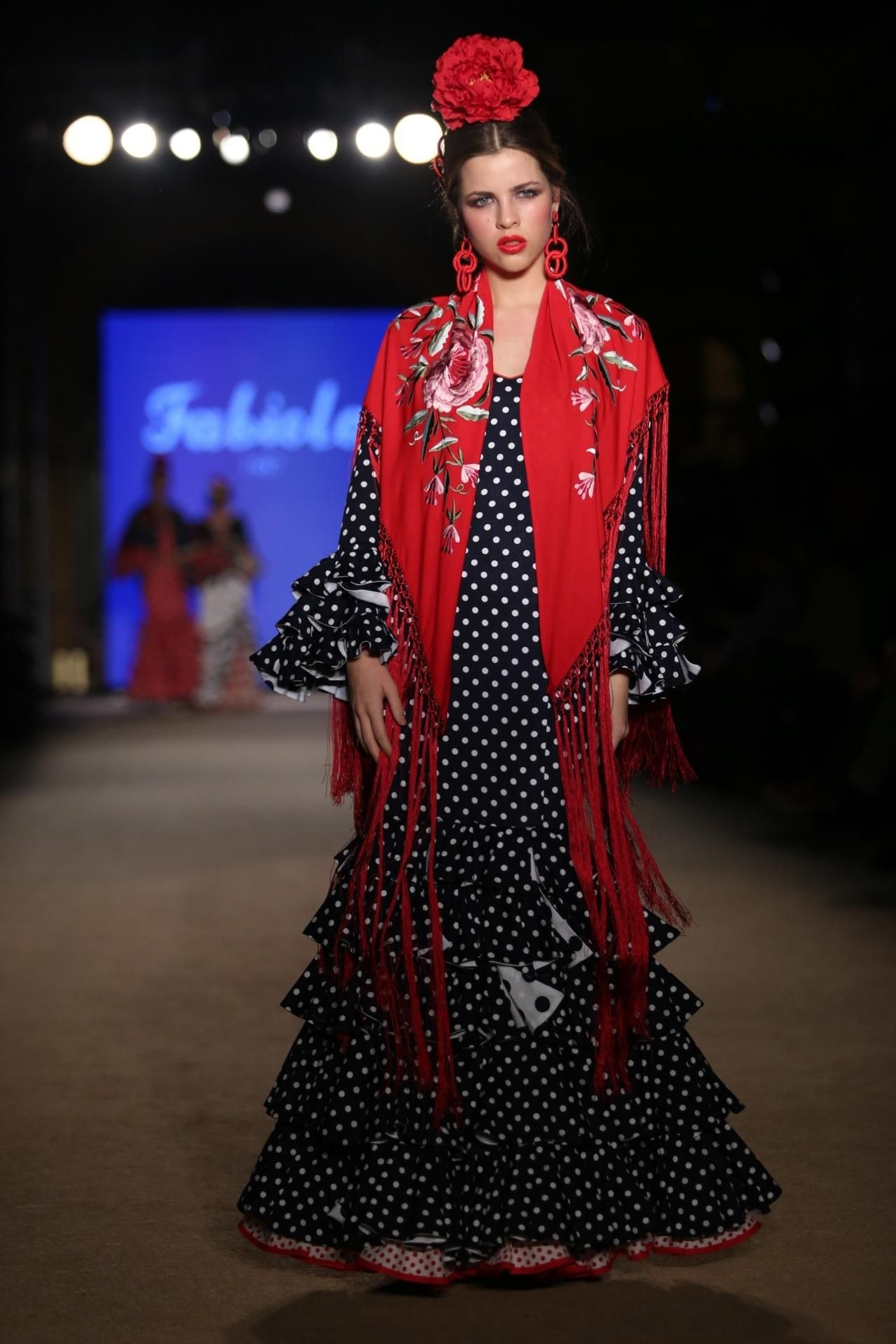 Rojo y bordados florales en combinación con el lunar blanco soble el negro. Eternos aliados. Traje de Fabiola en We Love Flamenco 2019. Fotografía de Belén Vargas.