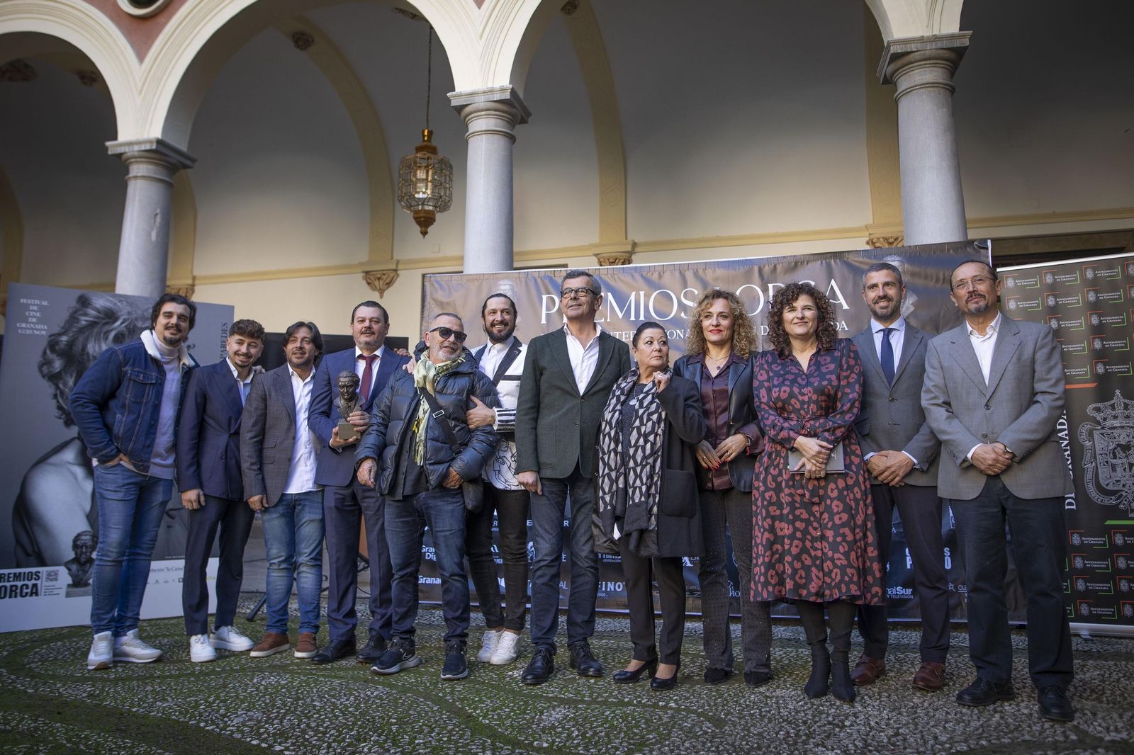 Las autoridades del evento de presentación posando junto al busto que se le otorgará a los premiados.
