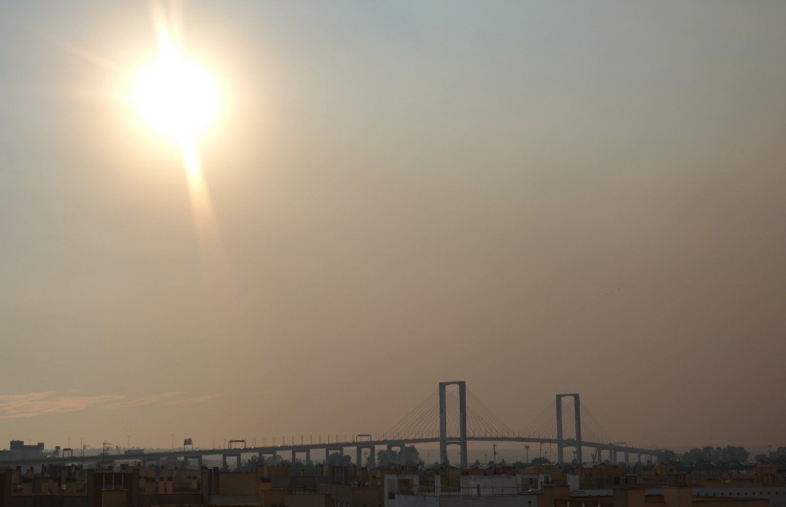 El humo cubre el puente del Centenario, en Sevilla.