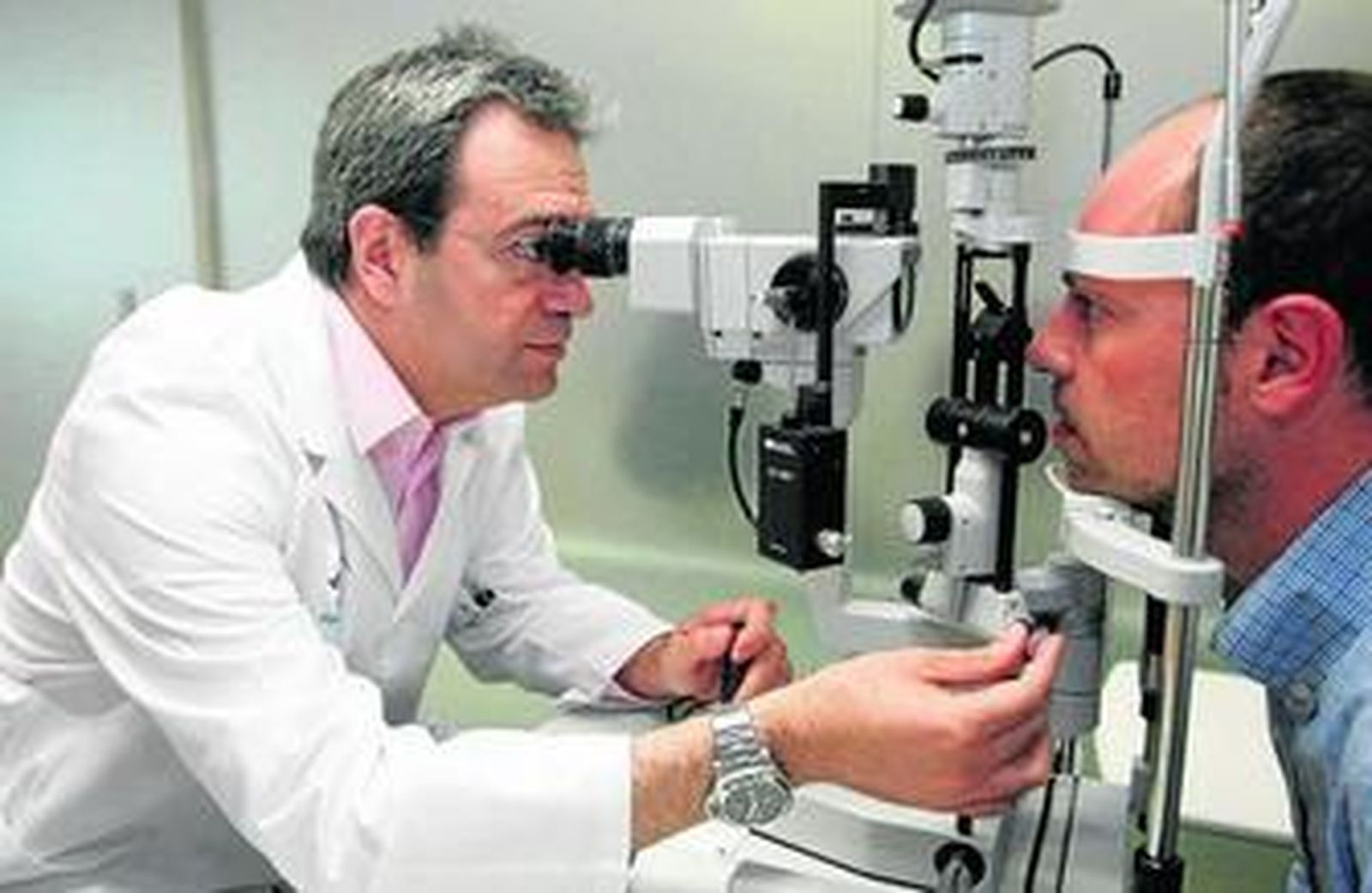 El doctor Joaquín Fernández realiza una exploración de la vista a un paciente en su clínica.