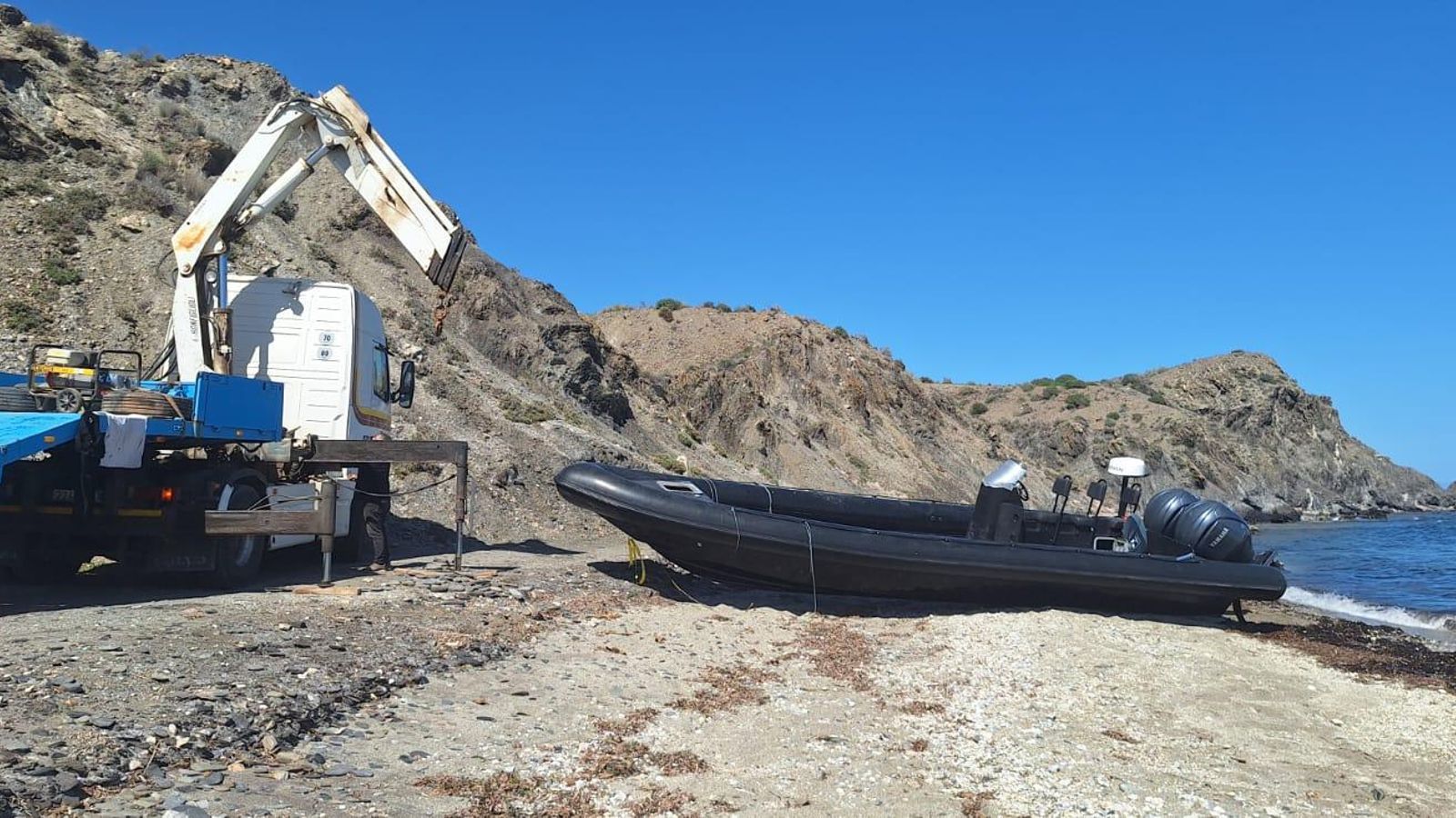Una semirrígida con dos motores retirada por la grúa en Cala Mochuela