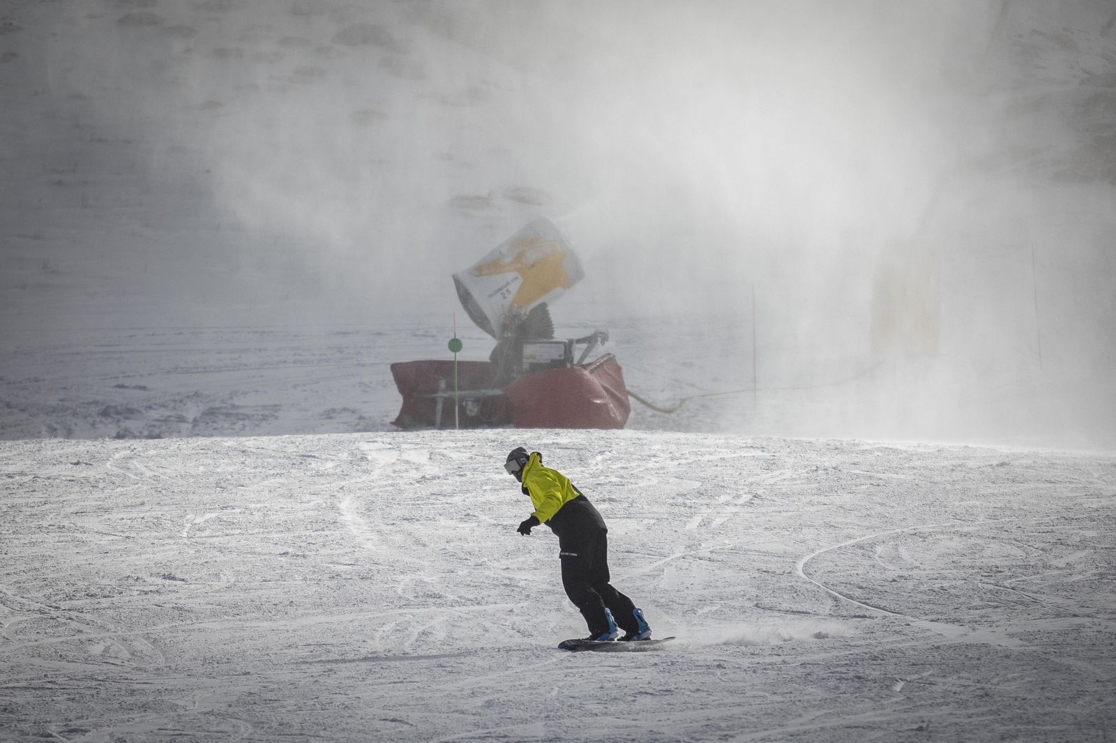 Imagen de archivo de un deportista pasando junto a un cañón de nieve artificial en Sierra Nevada