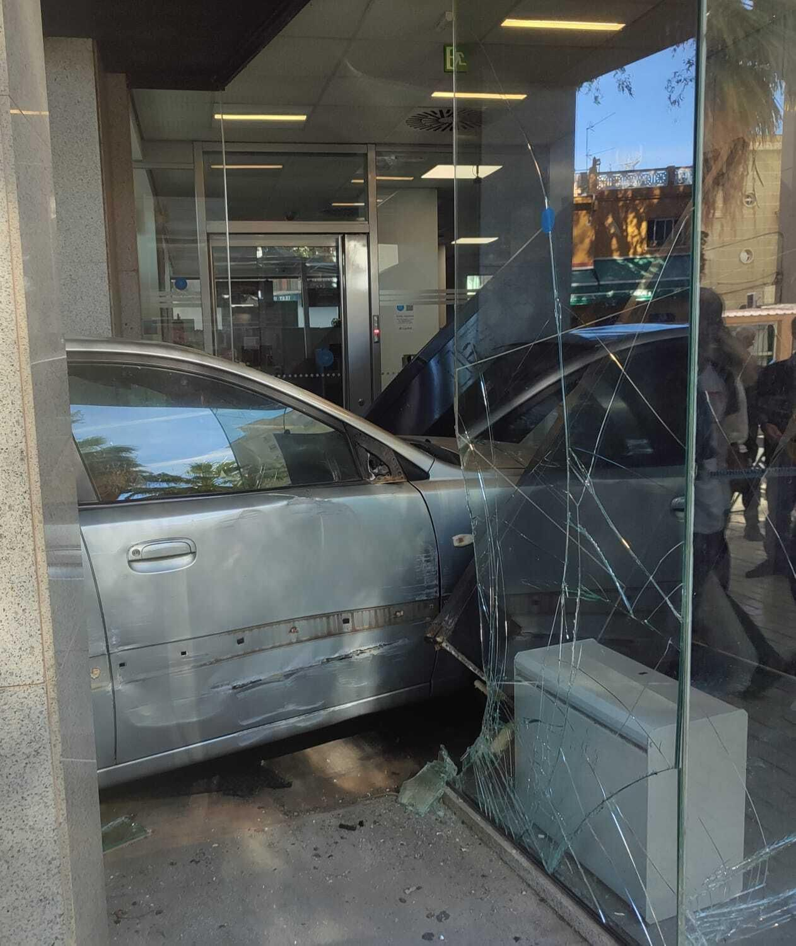 El vehículo, empotrado en el acceso de la oficina bancaria