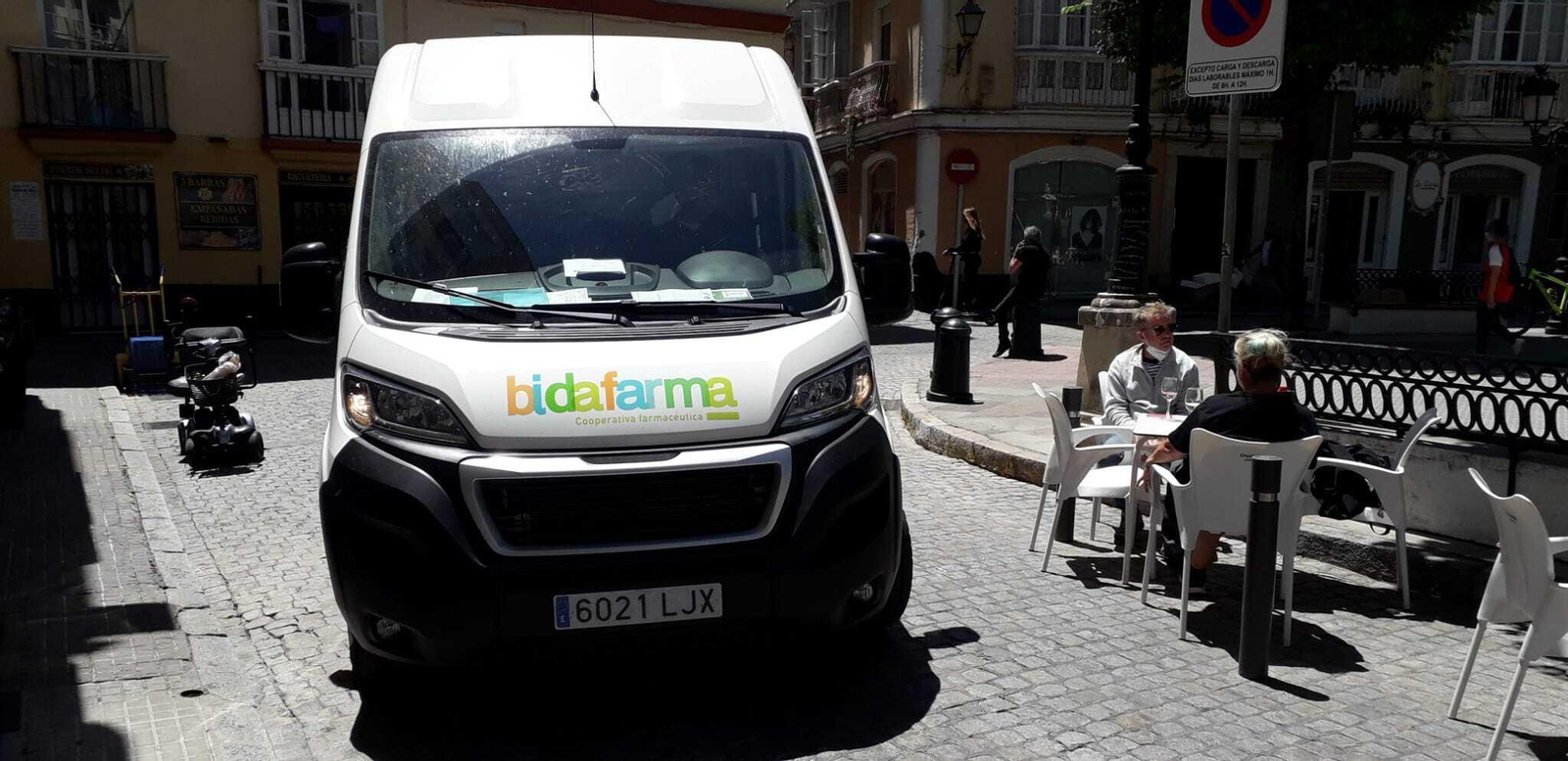 Una furgoneta pasa junto a una de las terrazas de la plaza de Candelaria.