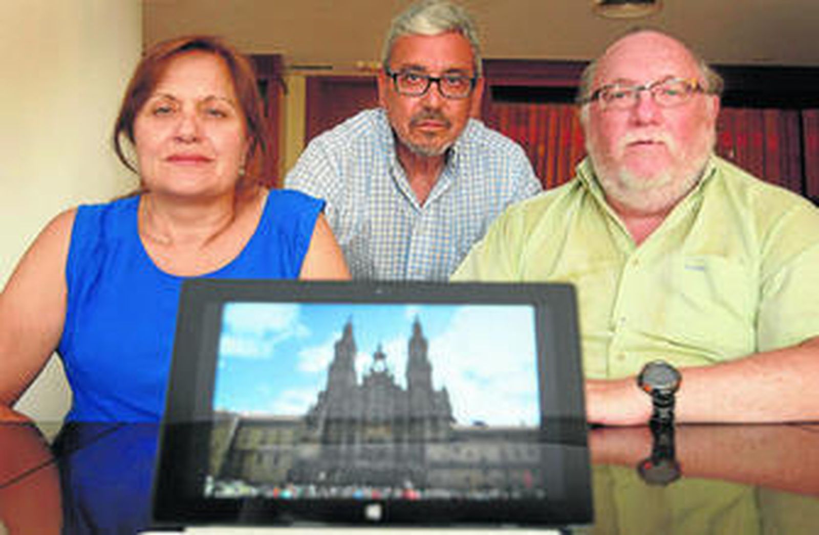 De izquierda a derecha, Isabel Rastrollo, José Pérez León y Francisco Tena Díaz, mostrando una imagen de la catedral de Santiago de Compostela.