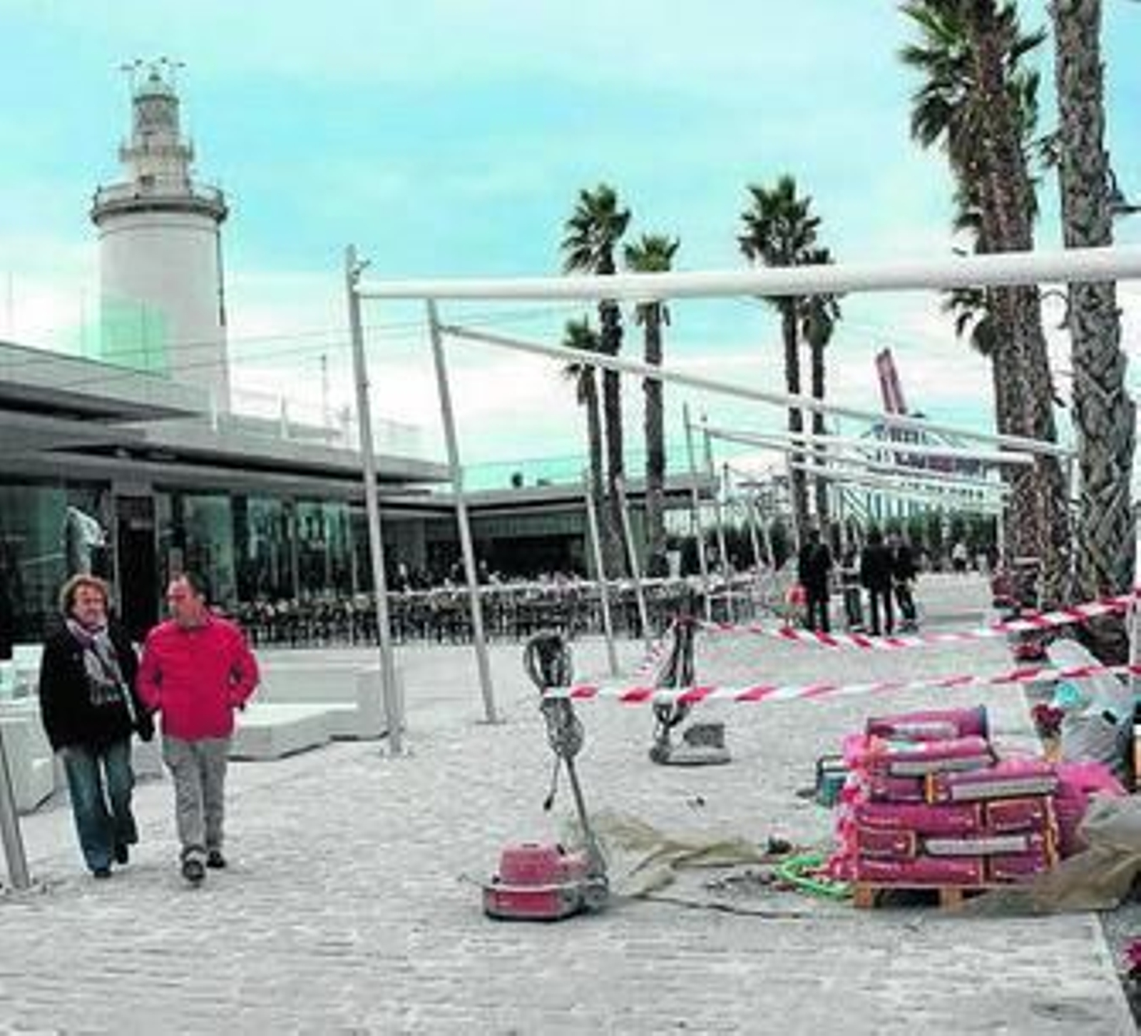 1. Un vecino entra a Muelle Uno por el acceso peatonal de la calle Vélez, parte del cual sigue en obras. 2. Dos clientes pasan junto a un punto del complejo aún en obras. 3. Una decena de personas deambula por la zona del centro comercial más próximo al edificio cultural, zona acotada por vallas, para impedir el acceso a la misma. 4. Un par de obreros trabajan en la construcción de la escalera que dará acceso a la 'esquina de oro' desde el Paseo de los Curas.