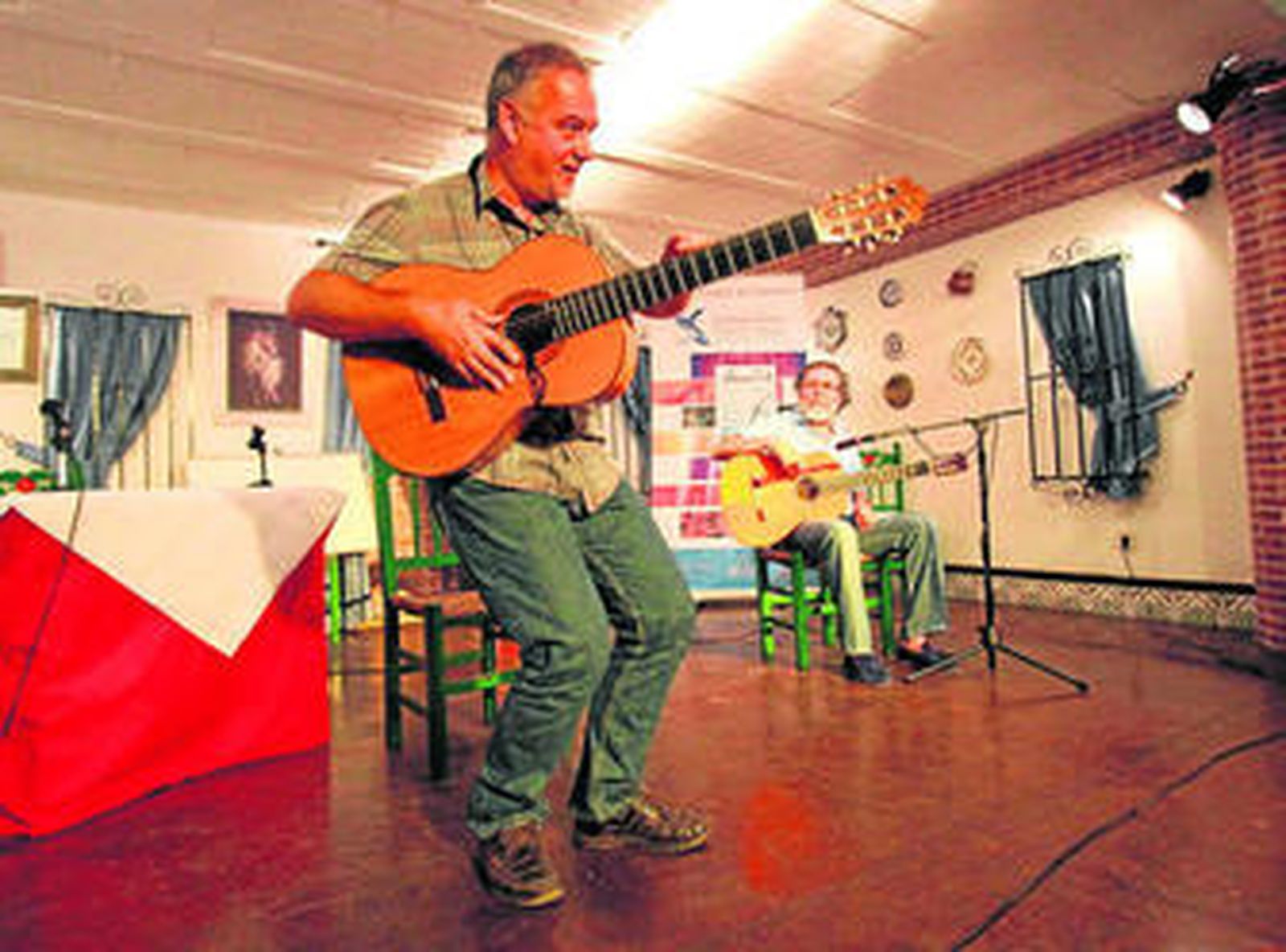Imagen de Faustino Núñez, durante la conferencia, junto a Diego Carrasco, sentado con la guitarra ayer.
