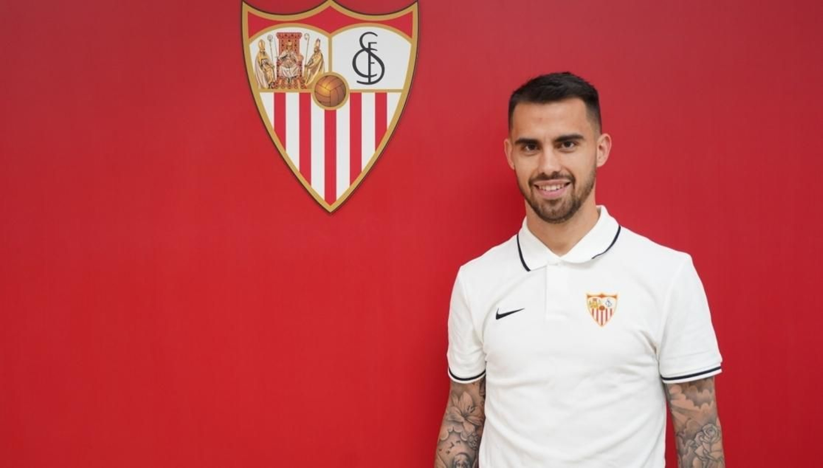Suso posa ante el escudo del Sevilla en las oficinas del club.
