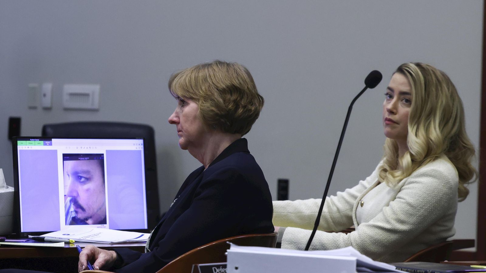 Amber Heard escucha el relato de su ex marido y ve una de las pruebas presentadas por él de una lesión presuntamente causada por ella.