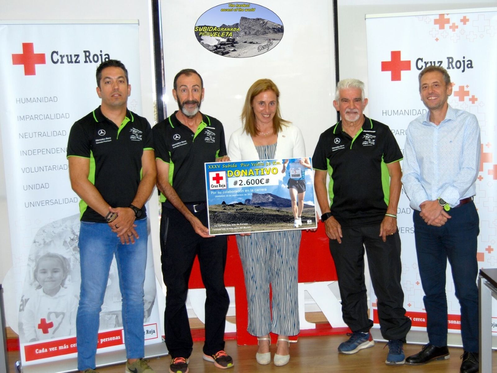 La presidenta de la Cruz Roja Granada recibe el cheque de manos de Enrique Carmona