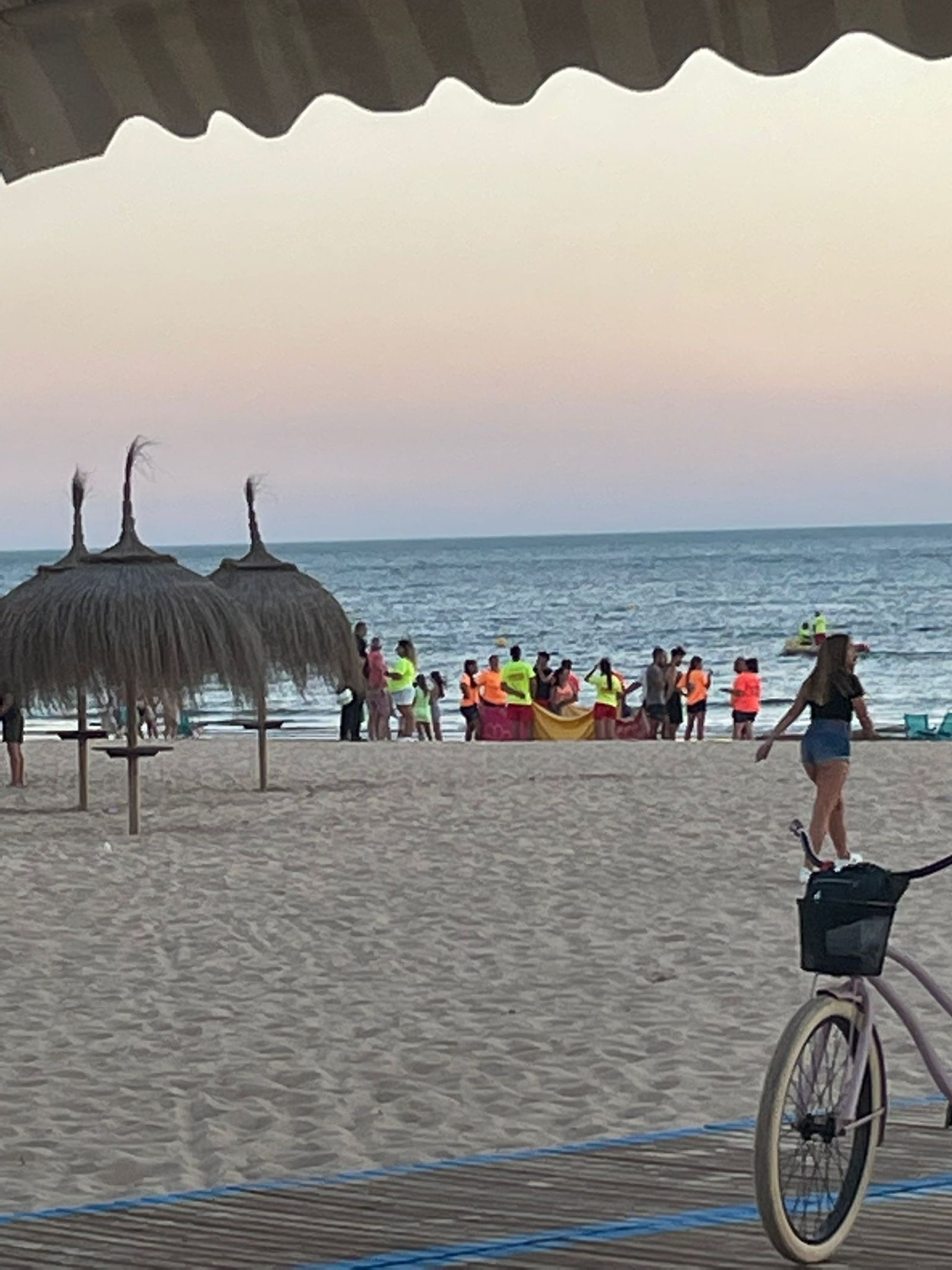 Los socorristas tapan el cuerpo del fallecido en la playa del Camarón en Chipiona.