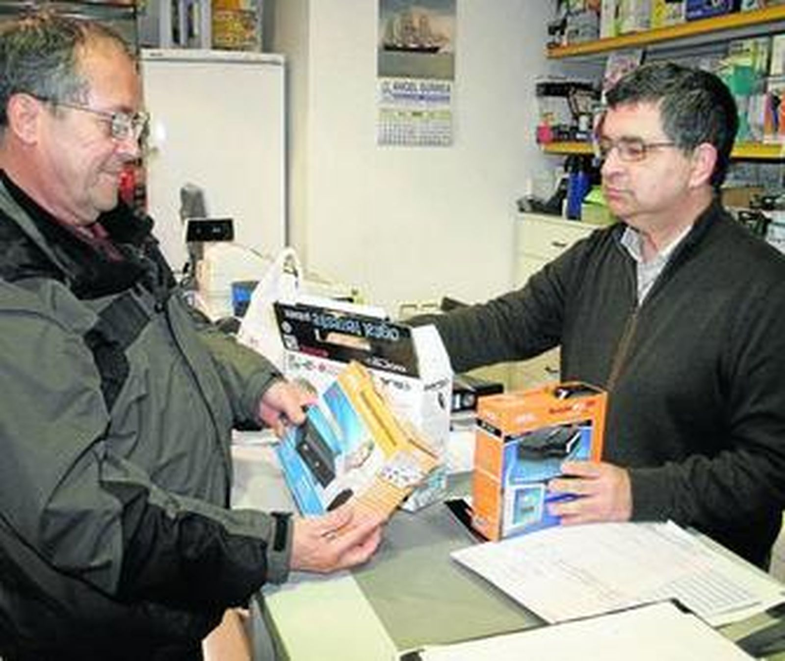 Un cliente se interesa por un sintonizador de TDT en una tienda de El Puerto.