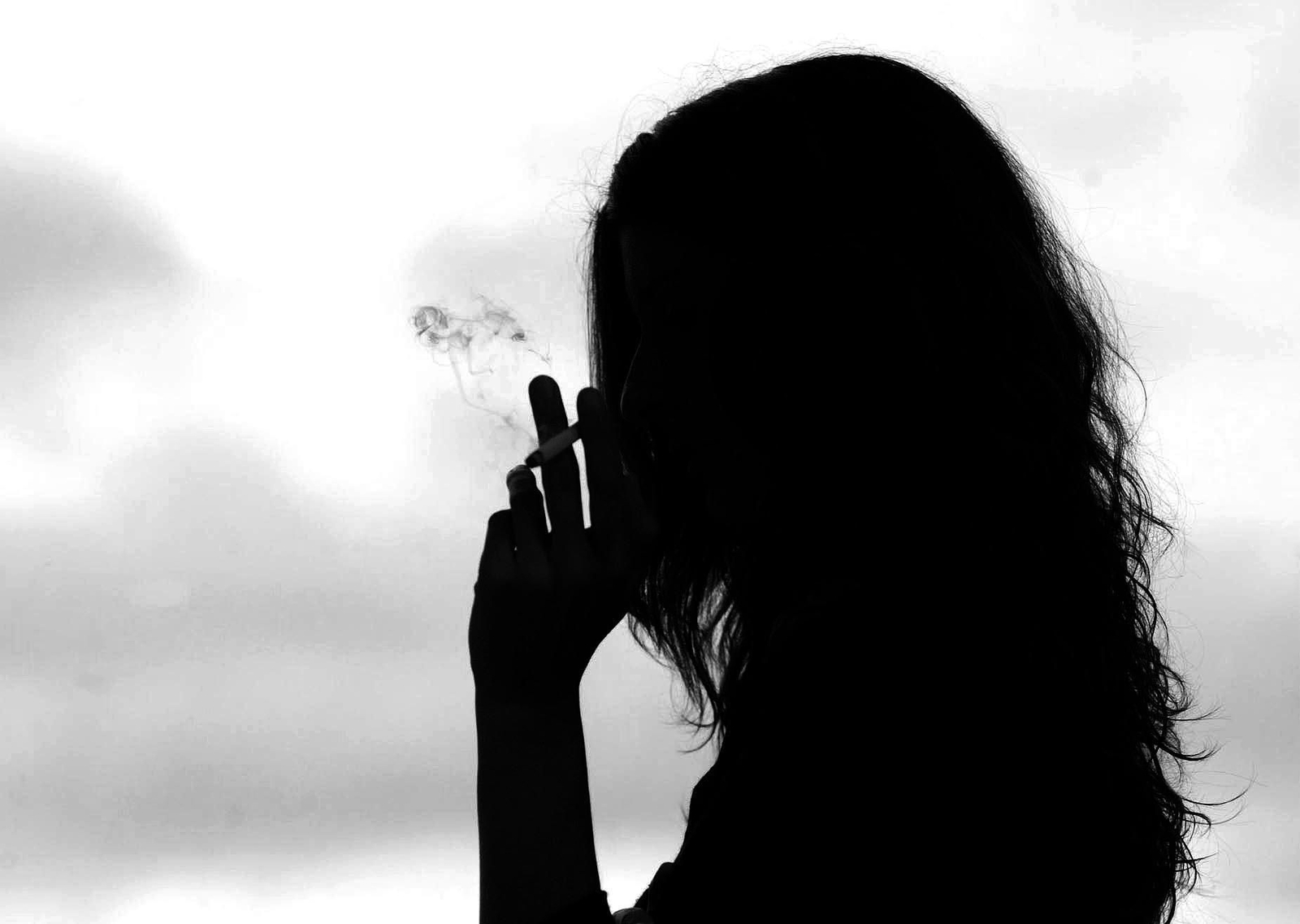 Una mujer fumando un cigarro.