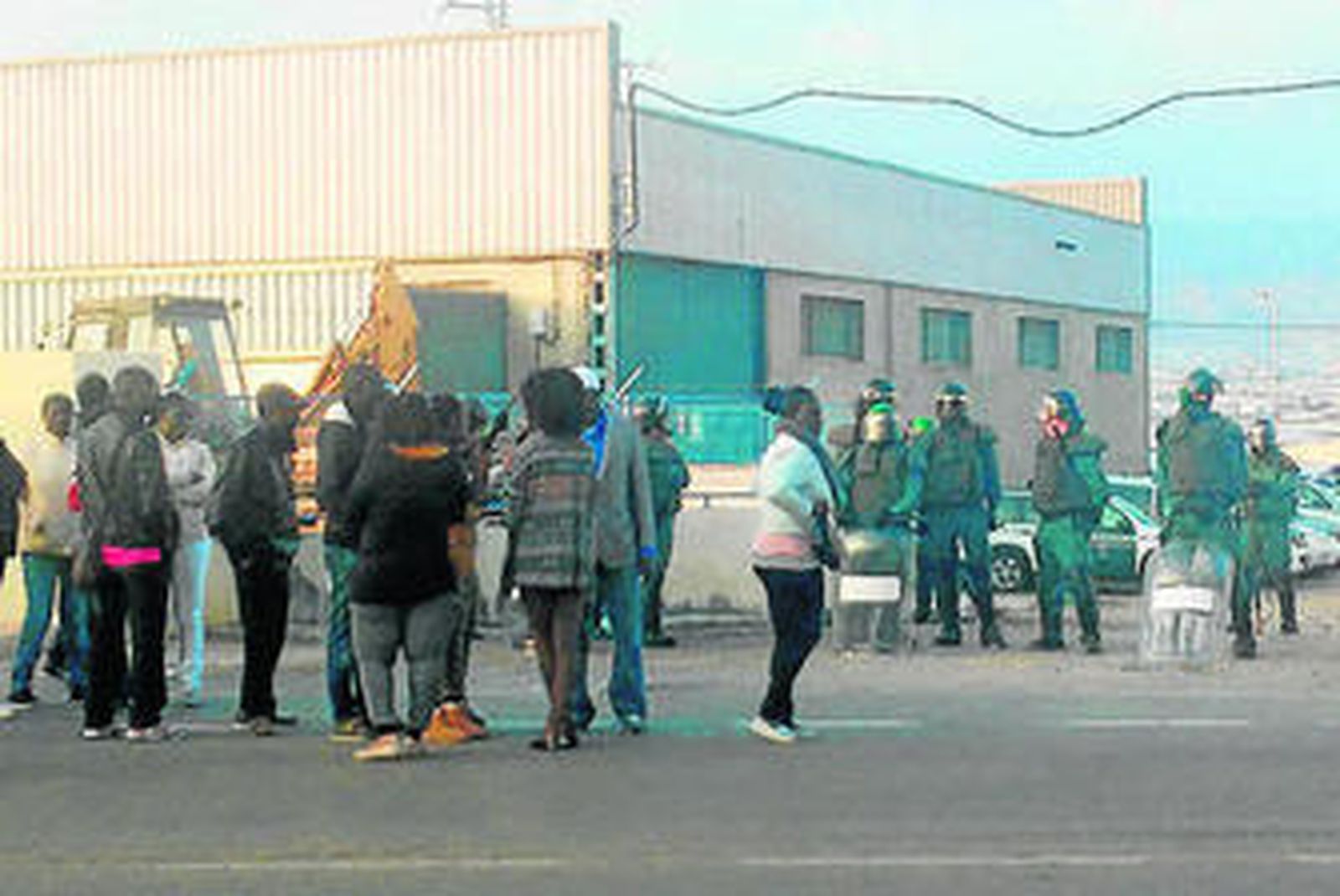 Inmigrantes ayer en Roquetas vigilados por agentes de la Guardia Civil.