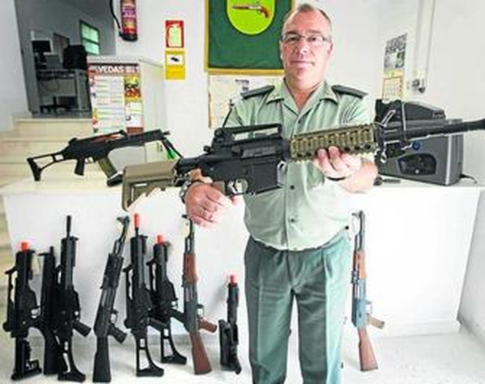 Un guardia de la Intervención sosteniendo una de las armas depositadas.