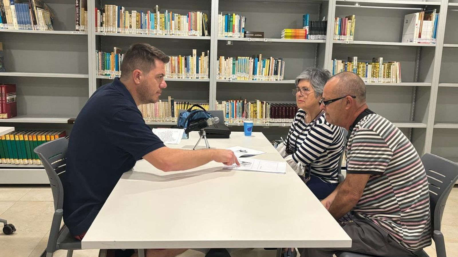 Herrero muestra unas fichas a dos de los voluntarios que han participado en la investigación.