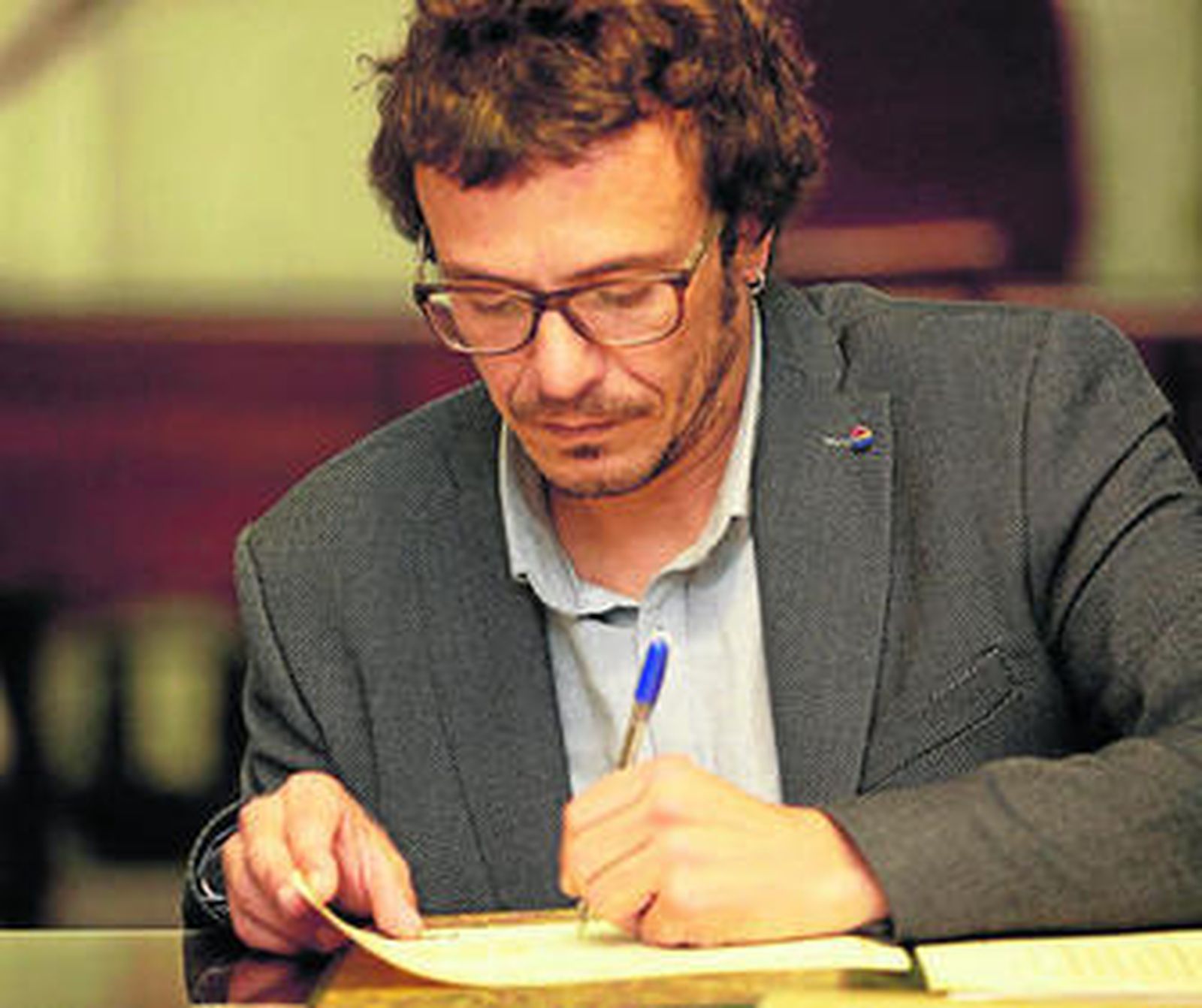 El alcalde firma documentos en su despacho del Ayuntamiento de Cádiz.