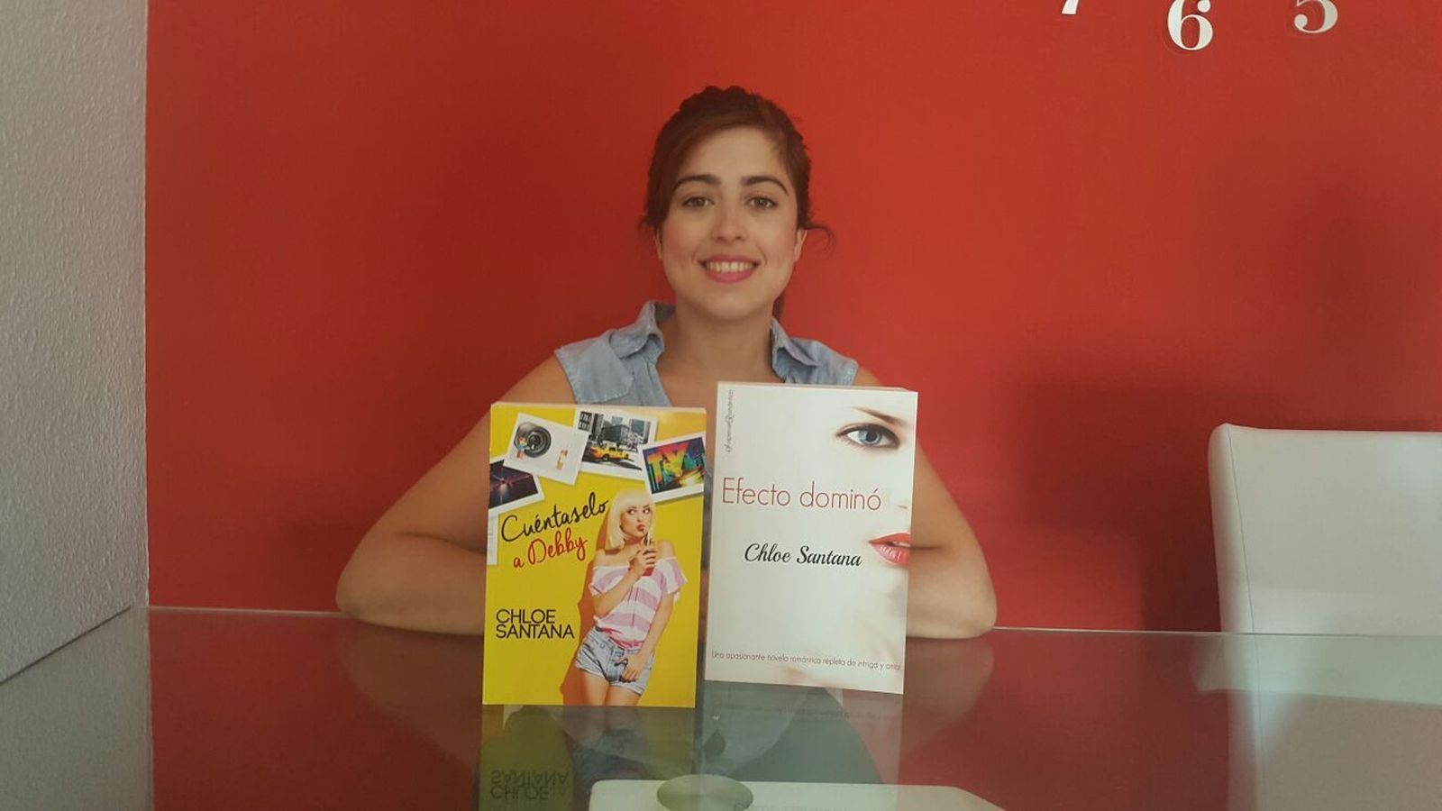Susana León, conocida como Chloe Santana en su faceta de escritora, posa junto a dos ejemplares de sus novelas.