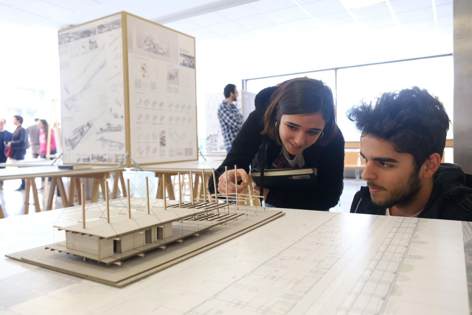 Dos estudiantes observan uno de los proyectos expuestos.