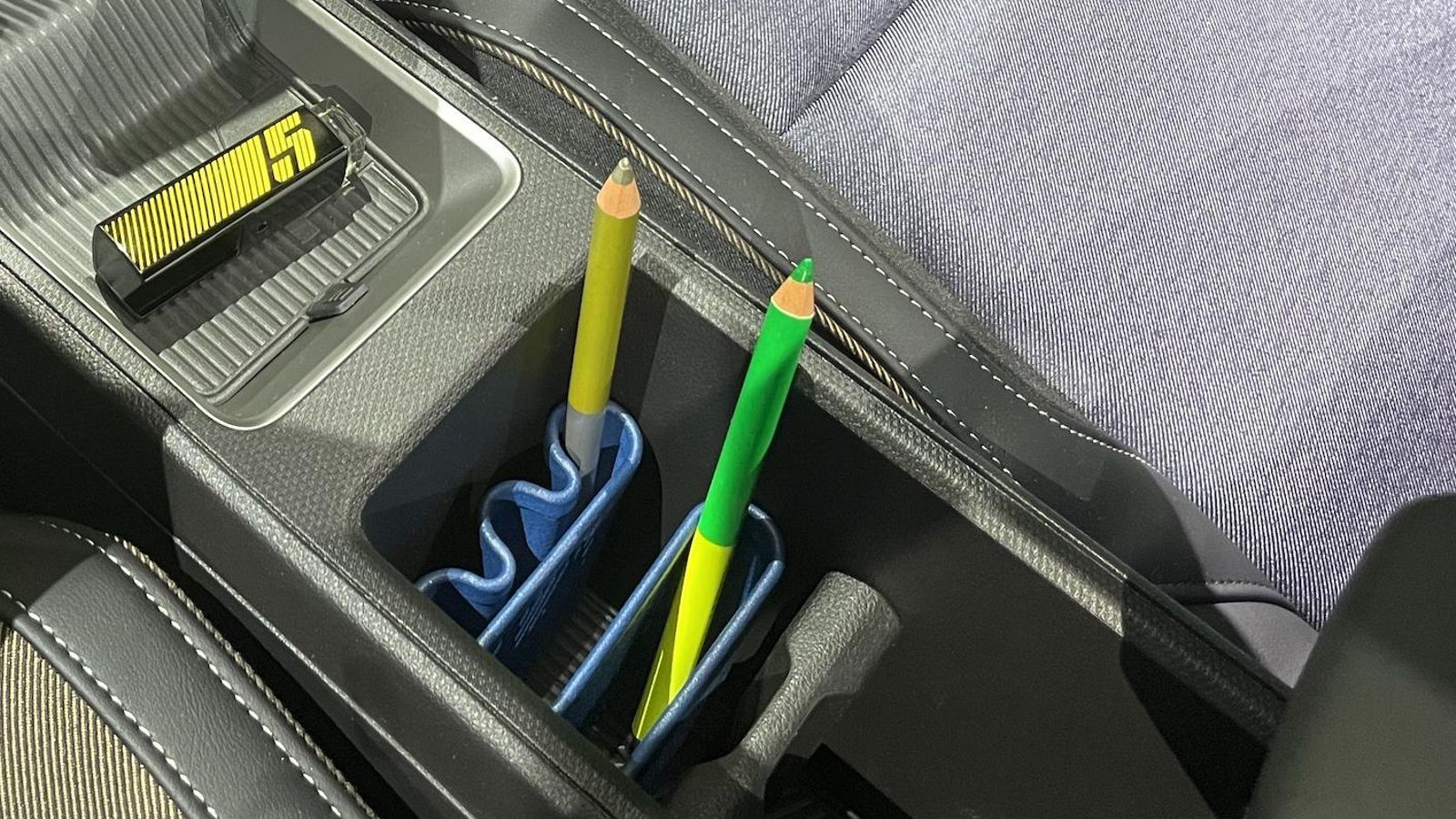 El selector del cambio puede incorporar un protector, como el que se ve en la imagen, inspirado en un pintalabios de chanel. Además, en los huecos entre los asientos se pueden situar distintos tipos de pequeños contenedores.