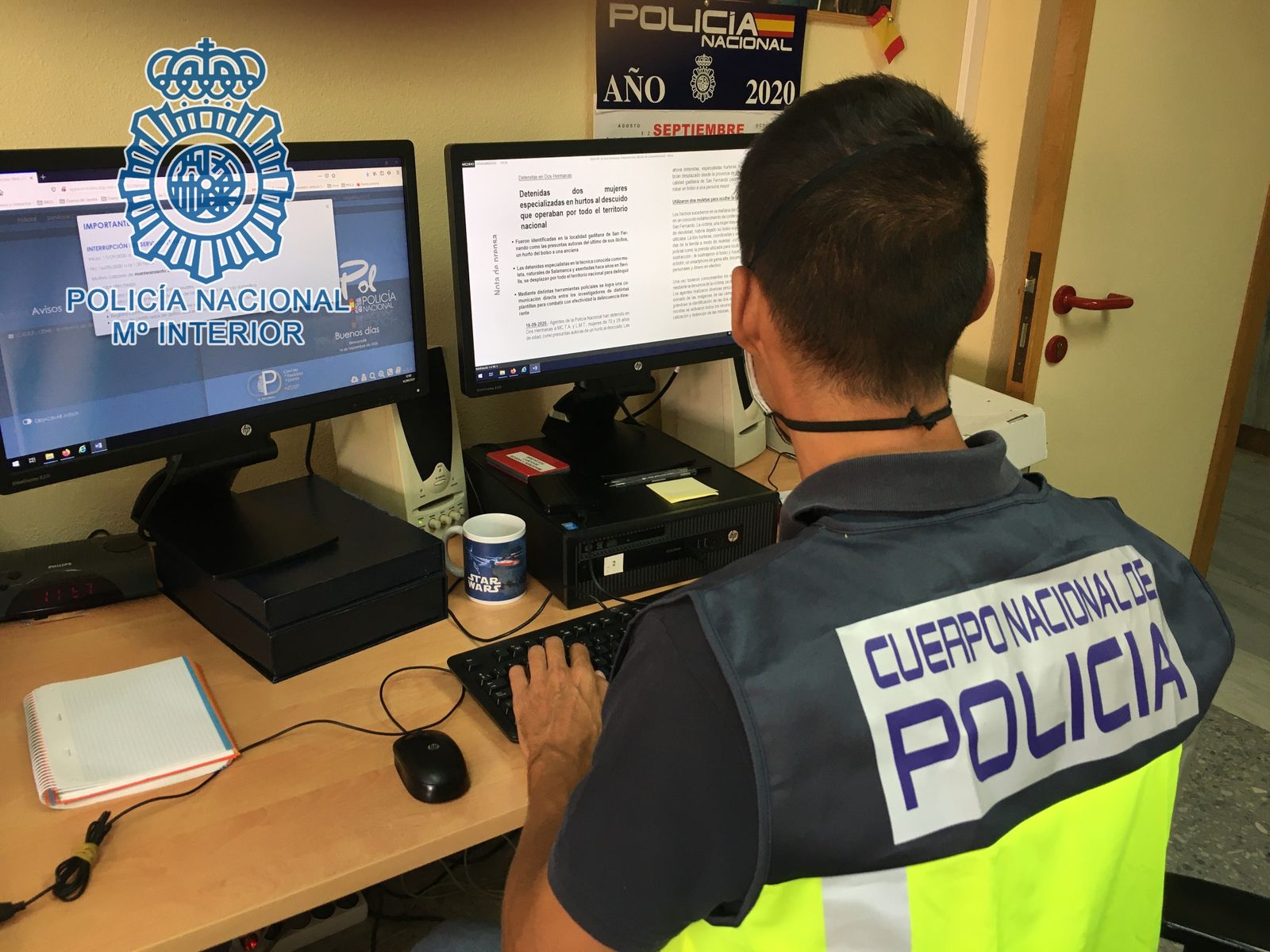 Un agente de la Policía Nacional trabaja con dos ordenadores.