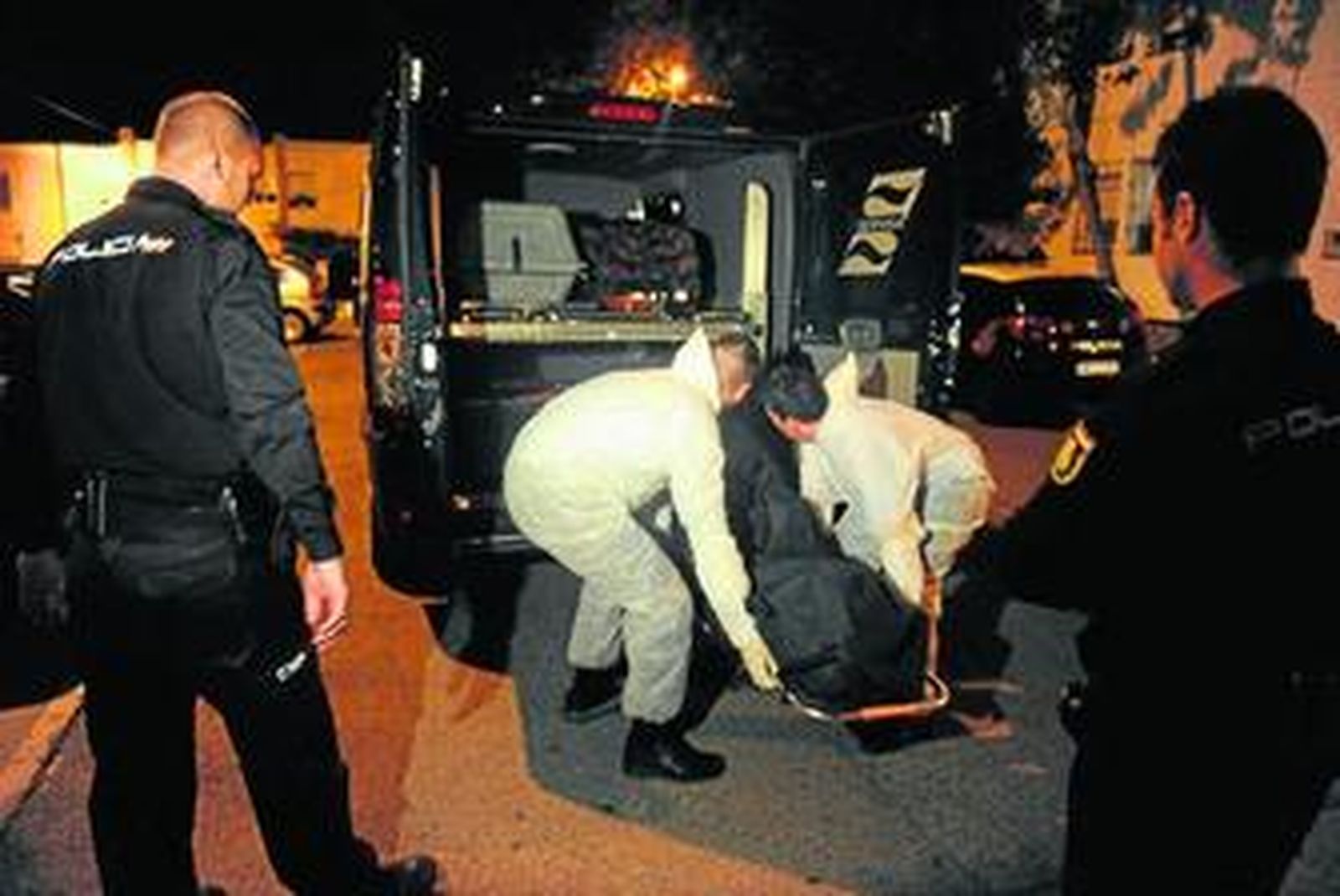 Personal de los servicios funerarios introducen el cuerpo sin vida del funcionario isleño asesinado ayer.
