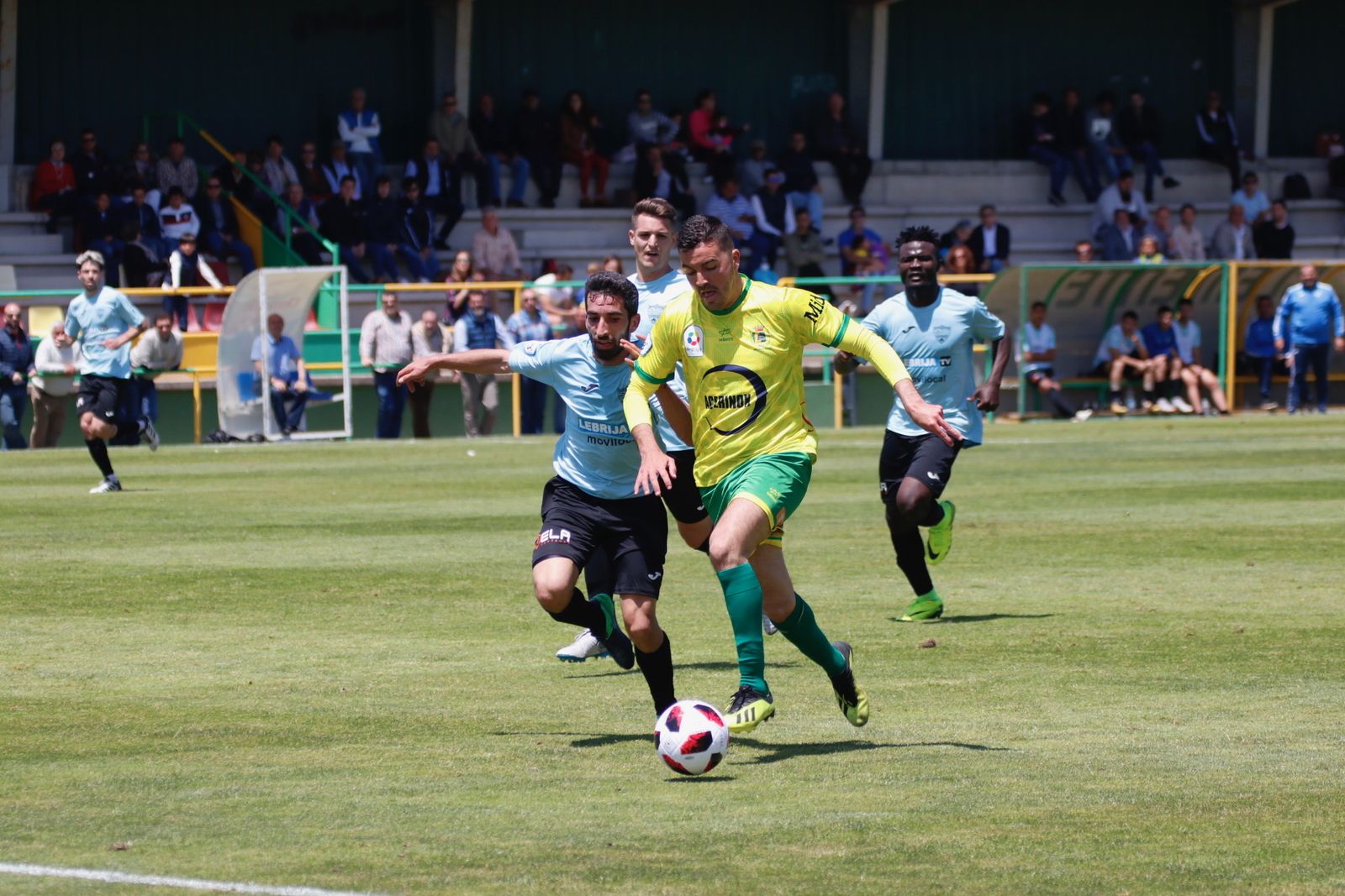El gualdiverde Ayala corre con el balón perseguido por un contrario.