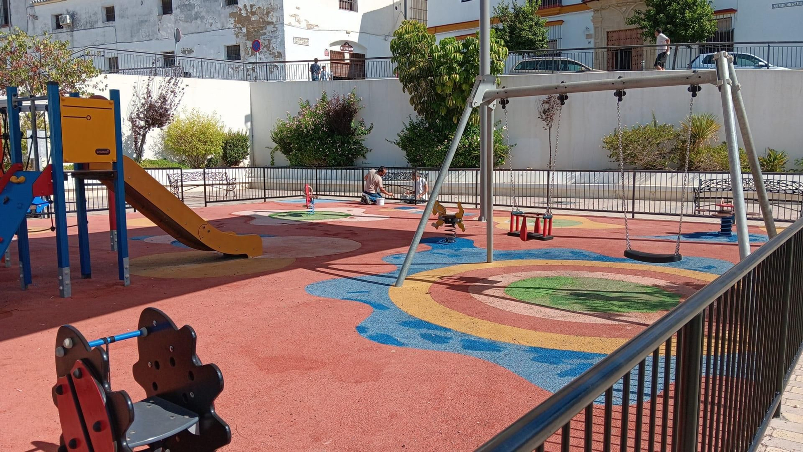 Operarios, pintando el vallado del parque infantil de la Plaza Belén.