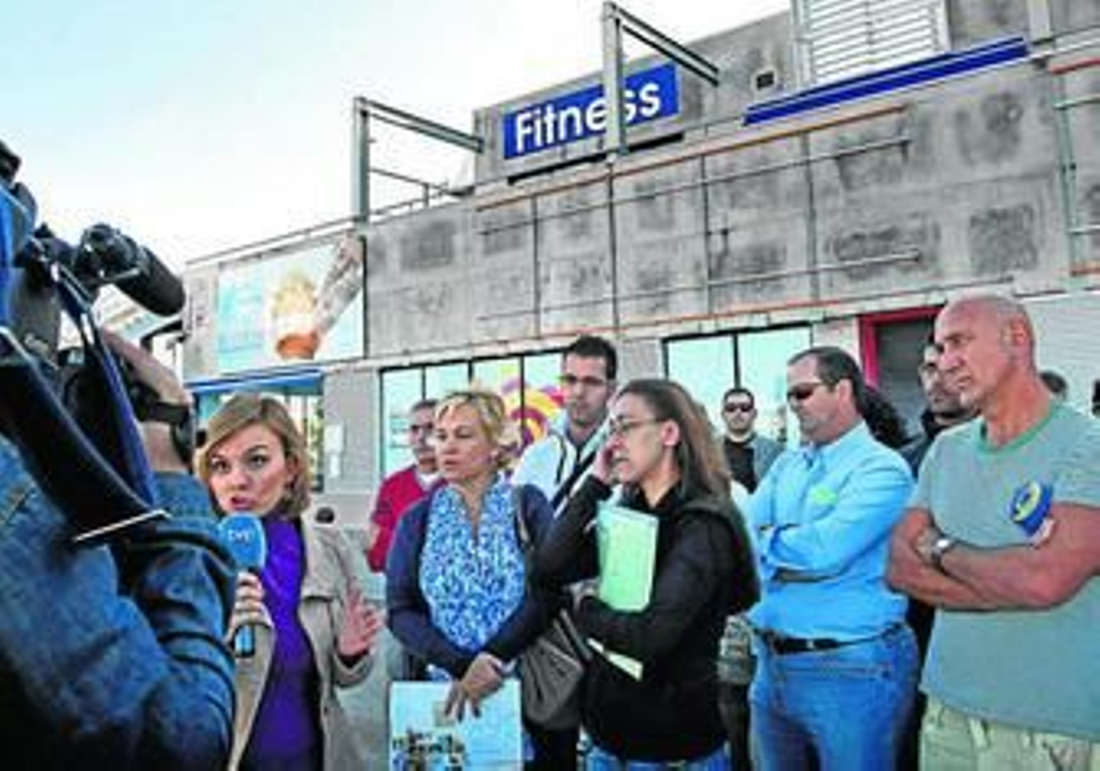 Algunos de los afectados por el cierre del antiguo Body Factory, junto a la reportera de TVE.