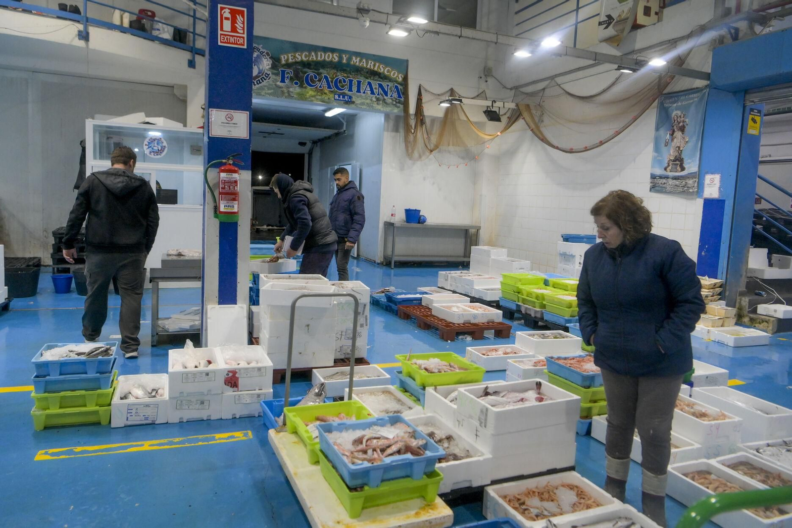 Varias personas observan el género en Mercagranada.