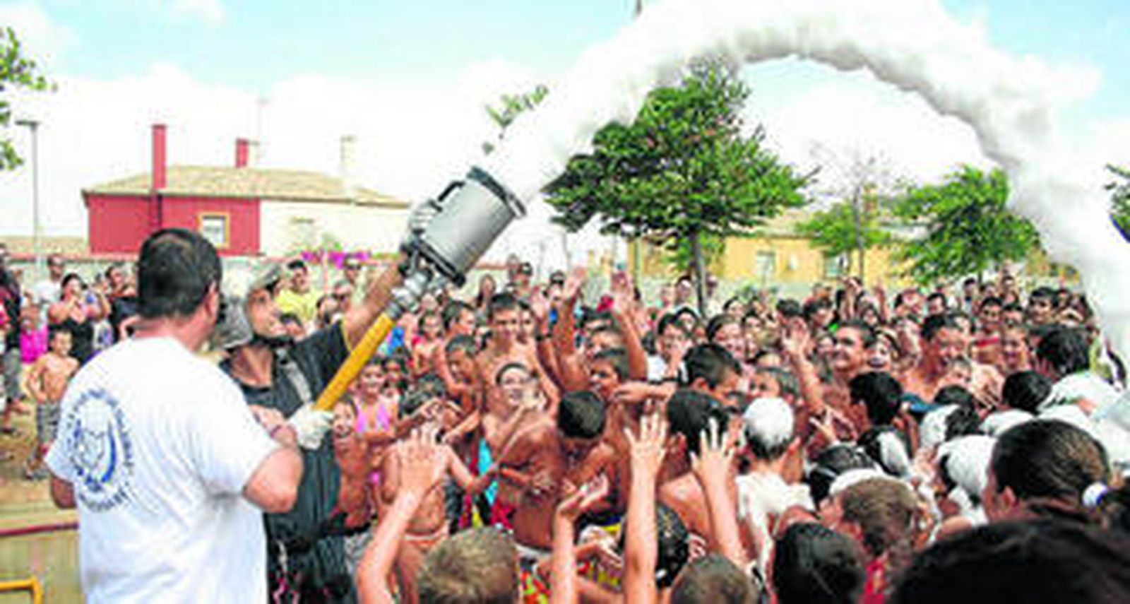 Un bombero lanza espuma a los niños, ayer, en San Bernabé.