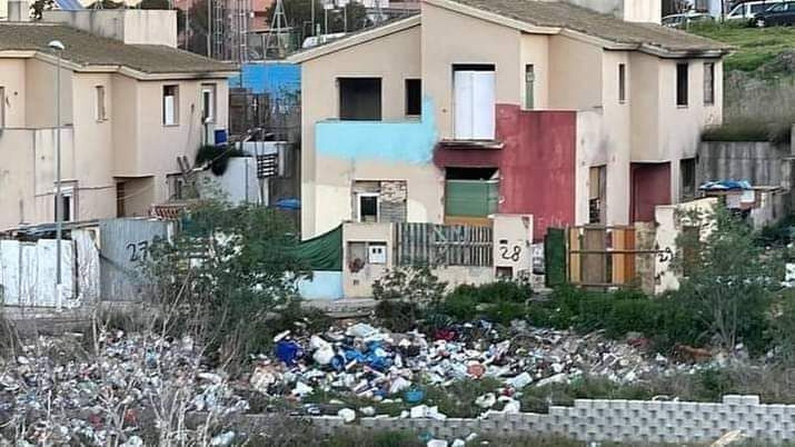 Vista de la basura junto a edificaciones abandonadas.