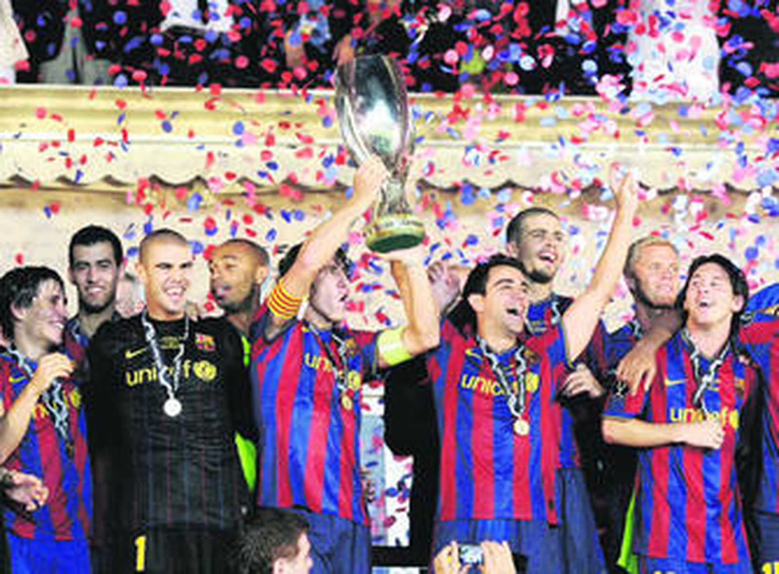 El capitán del Barcelona, Carles Puyol, junto a sus compañeros, levanta el trofeo que acredita al equipo de Guardiola como campeón de la Supercopa de Europa.