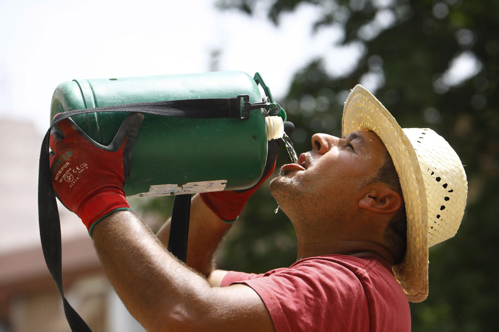 Un hombre se refresca con agua para combatir la calor. Un hombre se refresca con agua para combatir la calor.