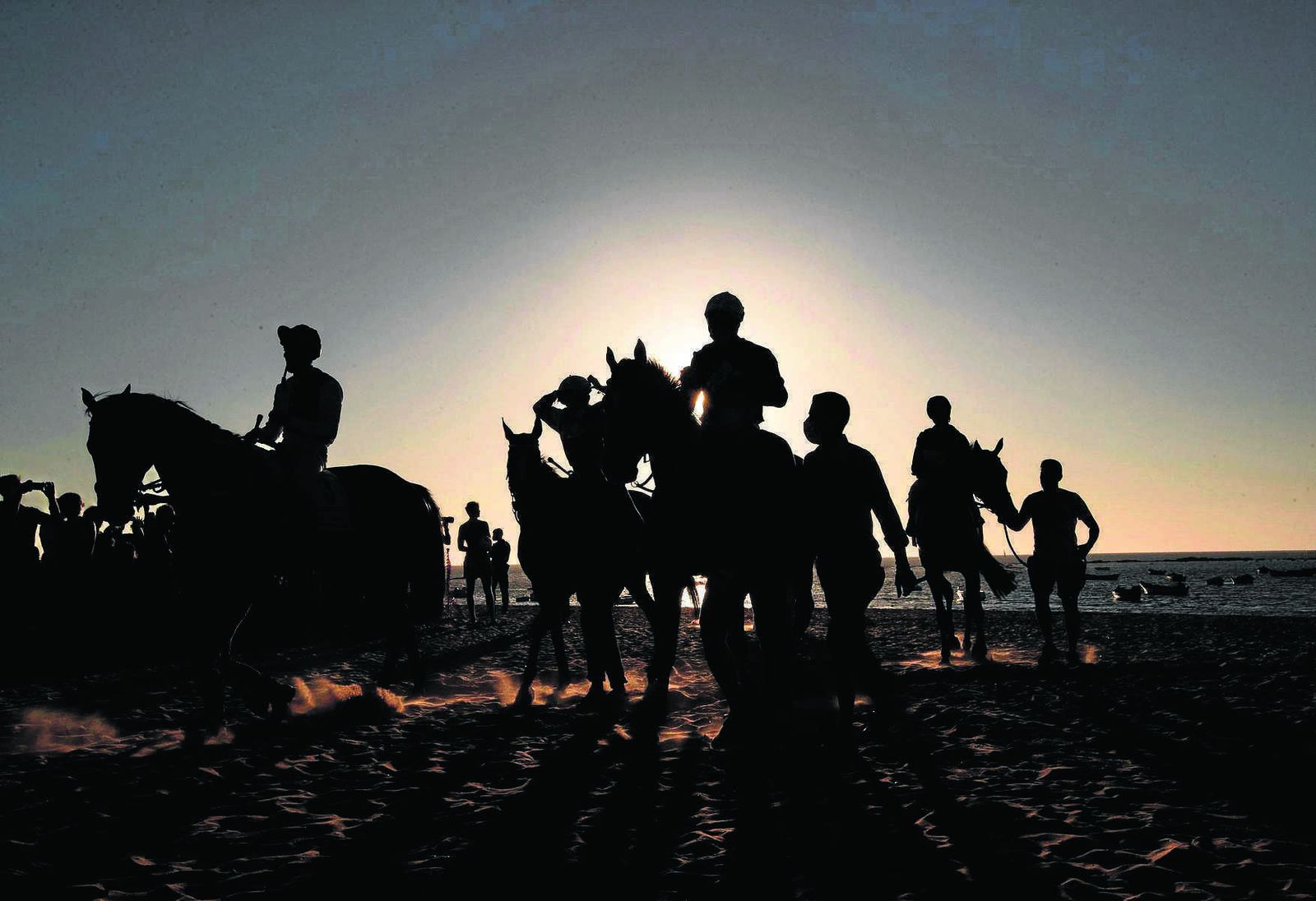 Fin de las pruebas del segundo día del primer ciclo, en el ocaso, de la 176ª edición de las carreras de caballos celebrada el pasado viernes en las playas de Sanlúcar de Barrameda.