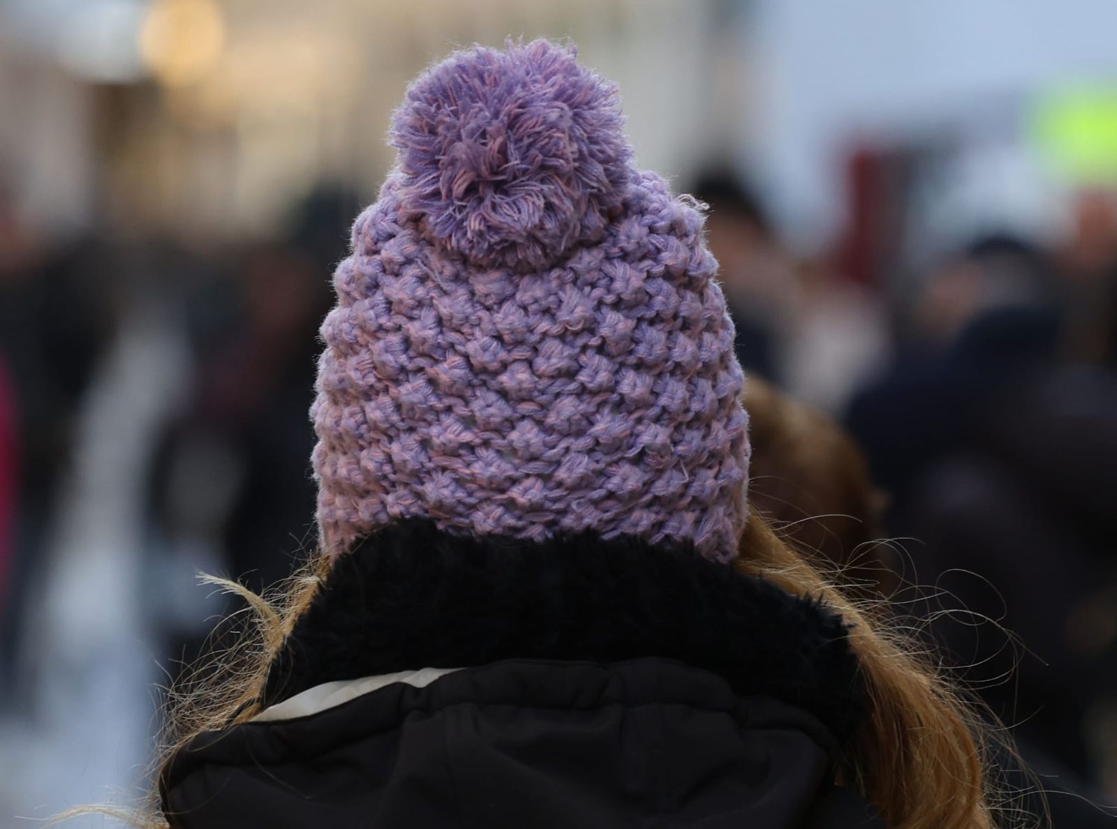 Una mujer se protege del frío en Málaga con un gorro.