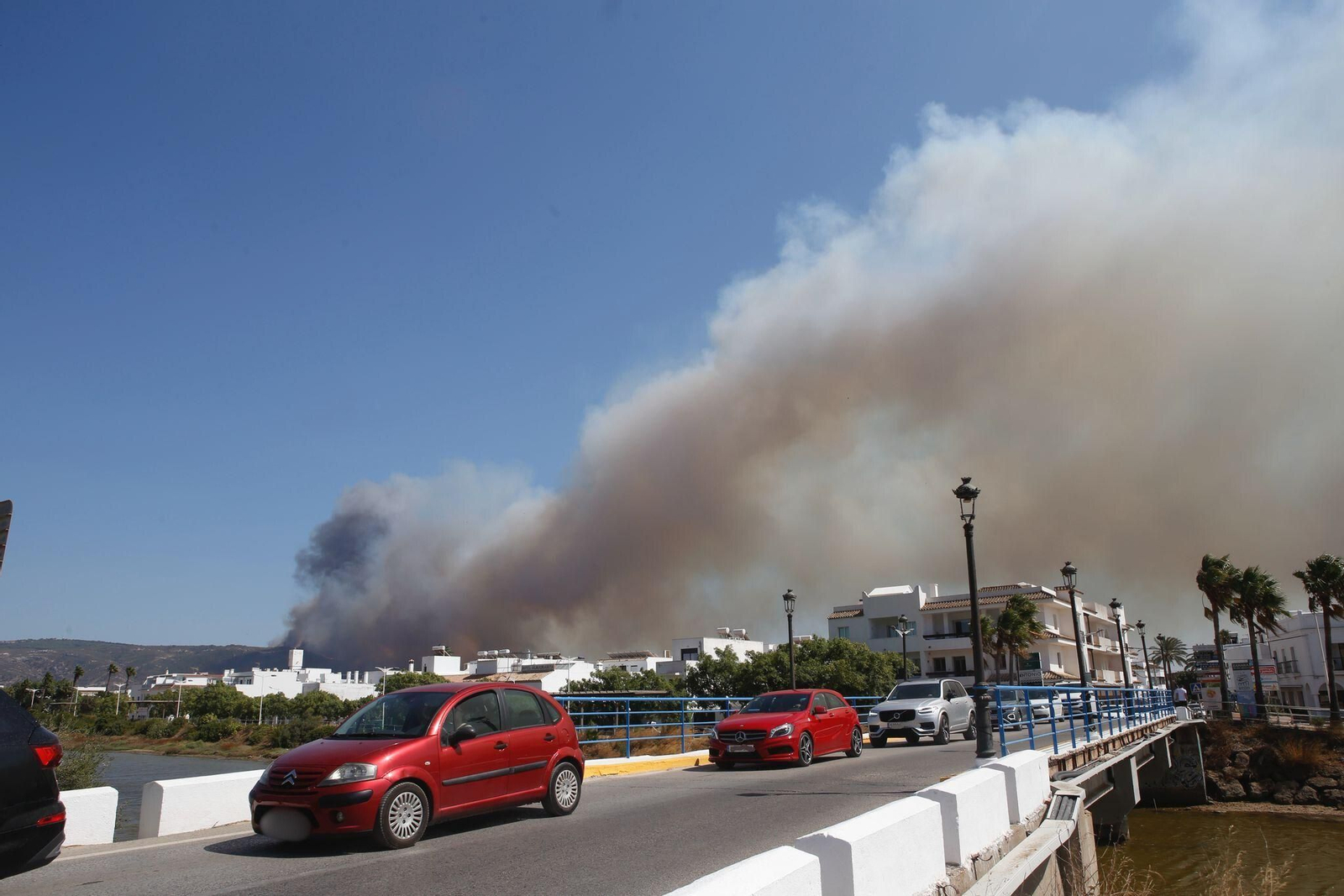 Coches abandonando Atlanterra a causa del incendio.