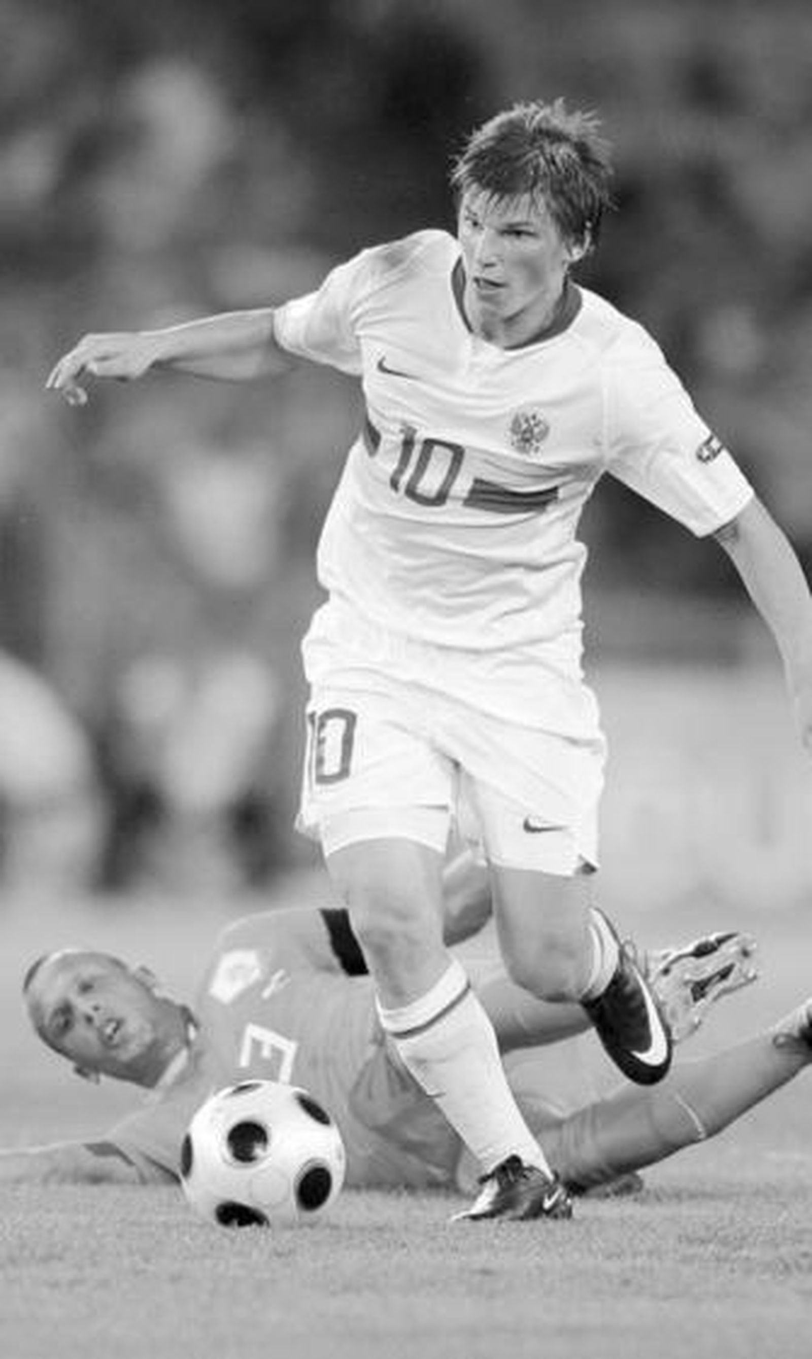 El ruso Arshavin conduce la pelota después de driblar al holandés Heitinga.