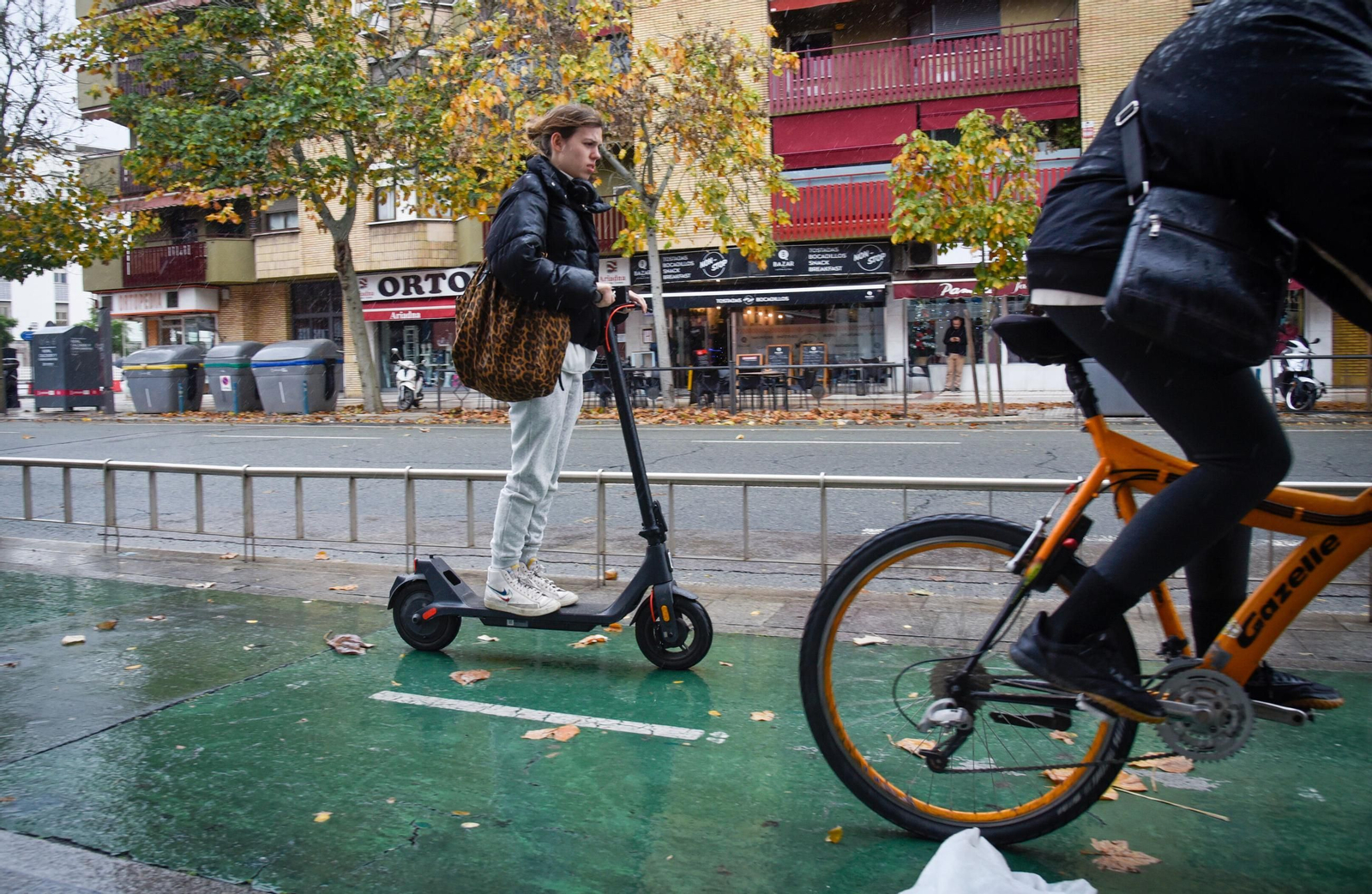 Una usuaria de patinete y un ciclista por el carril bici de la Ronda Histórica.