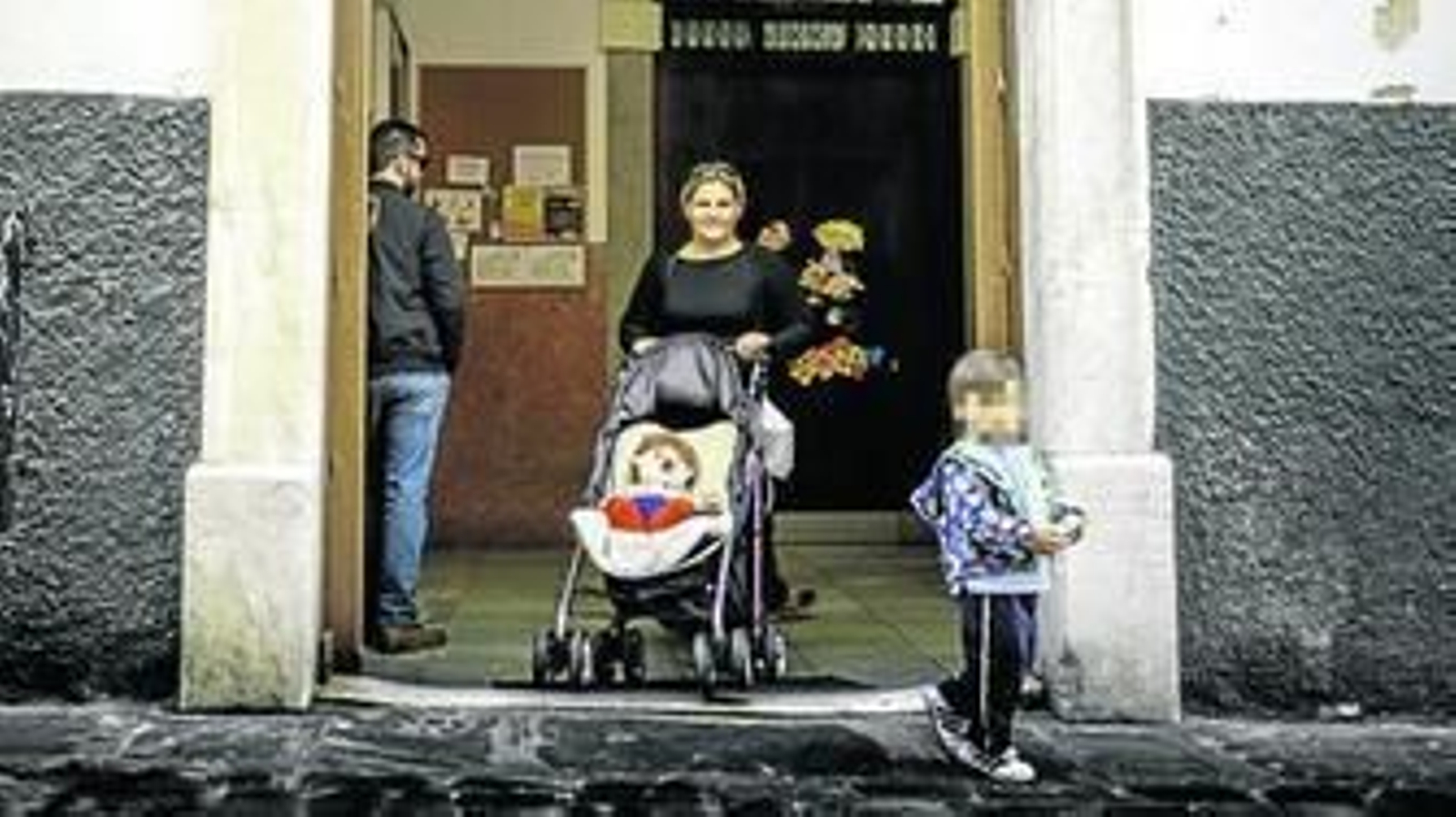 Una madre porta un carro con un muñeco a la salida del Centro de Educación Infantil San Martín.