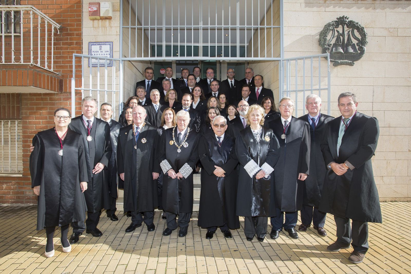 Foto de familia de autoridades y galardonados en la Plaza de los Abogados de Huelva.