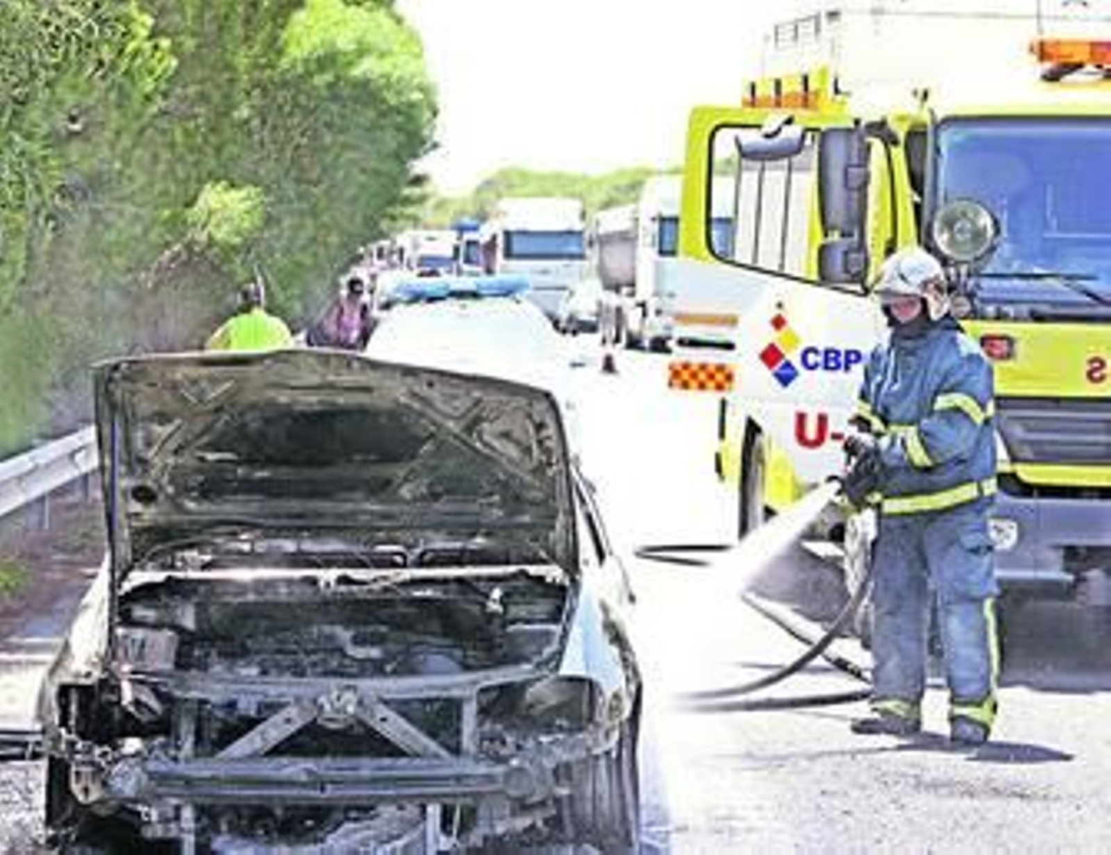 Un bombero refresca el coche que se quemó ayer en la AP-4.