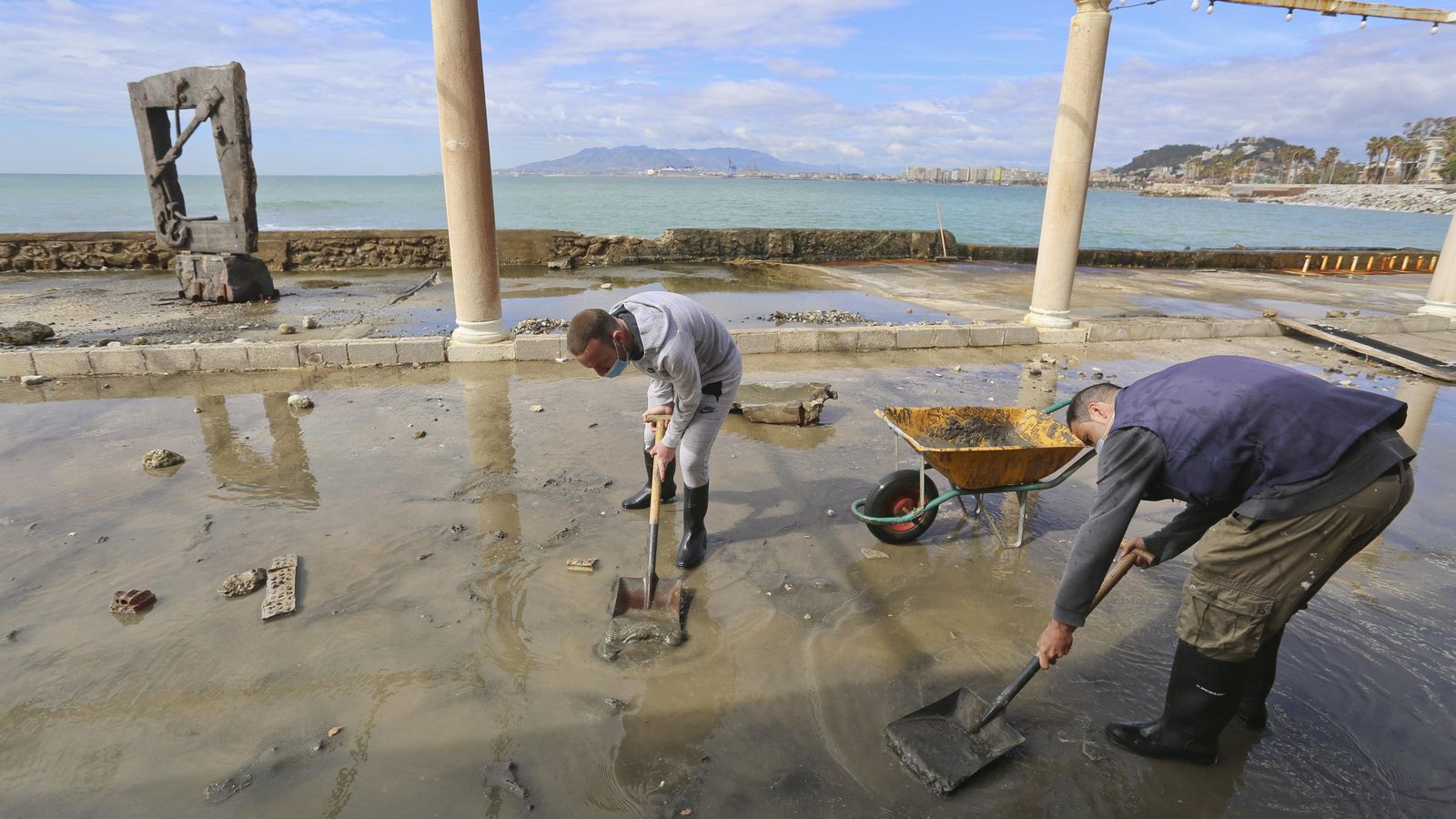 Dos operarios reparan los daños causados en un chiringuito de Málaga después del último temporal.