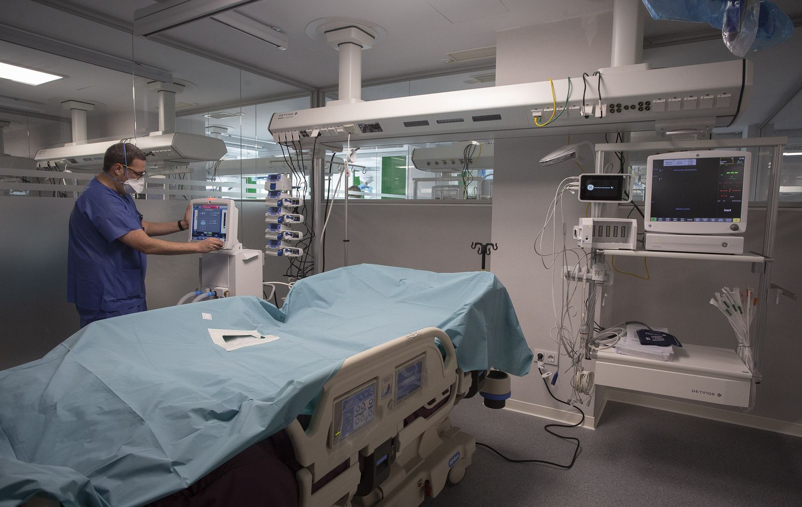 Un sanitario prepara el monitor de una de las habitaciones de UCI del hospital previo a su inauguación.