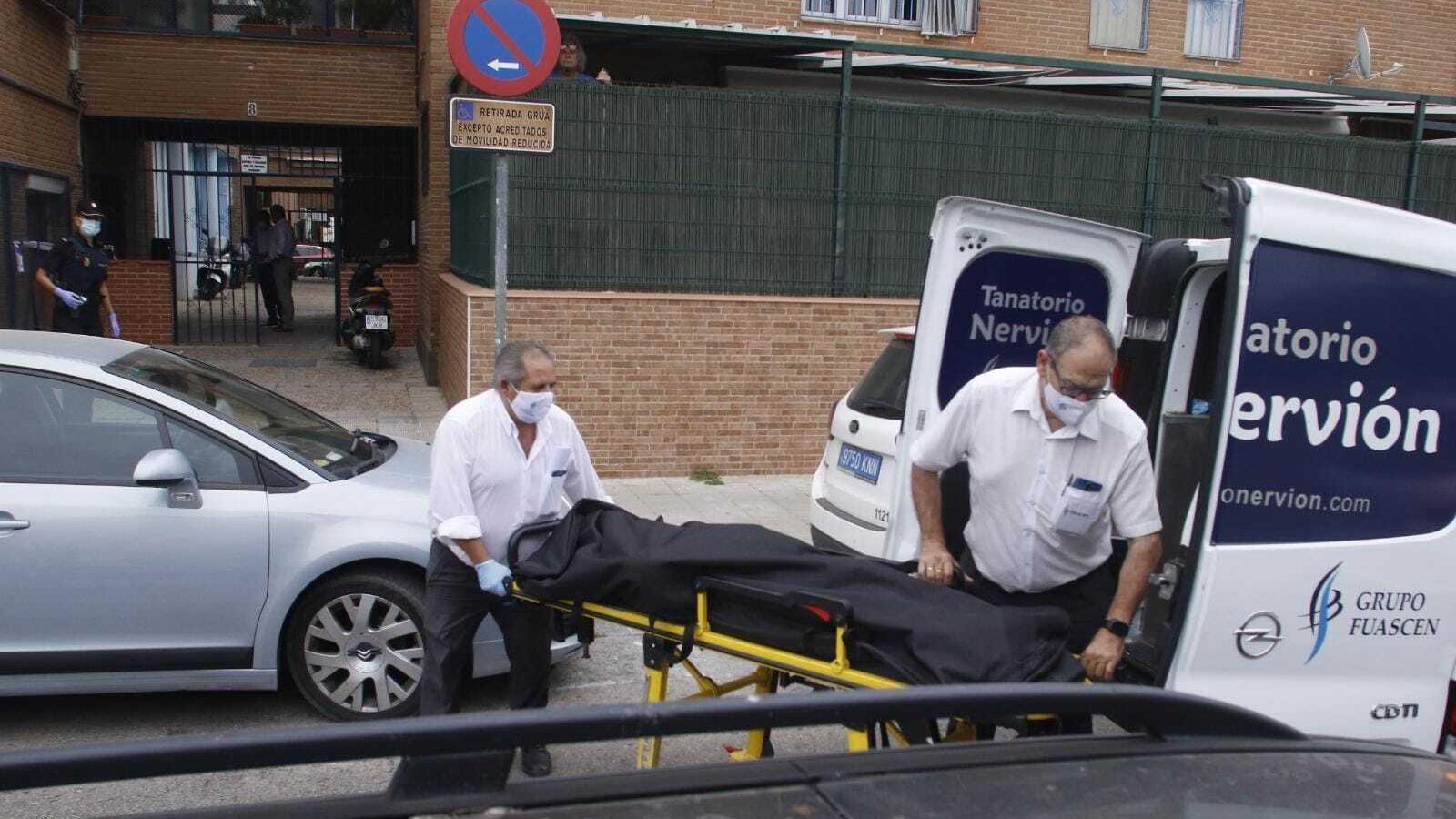 Momento en el que los servicios funerarios sacan el cadáver del domicilio de la víctima, la mañana de este jueves.