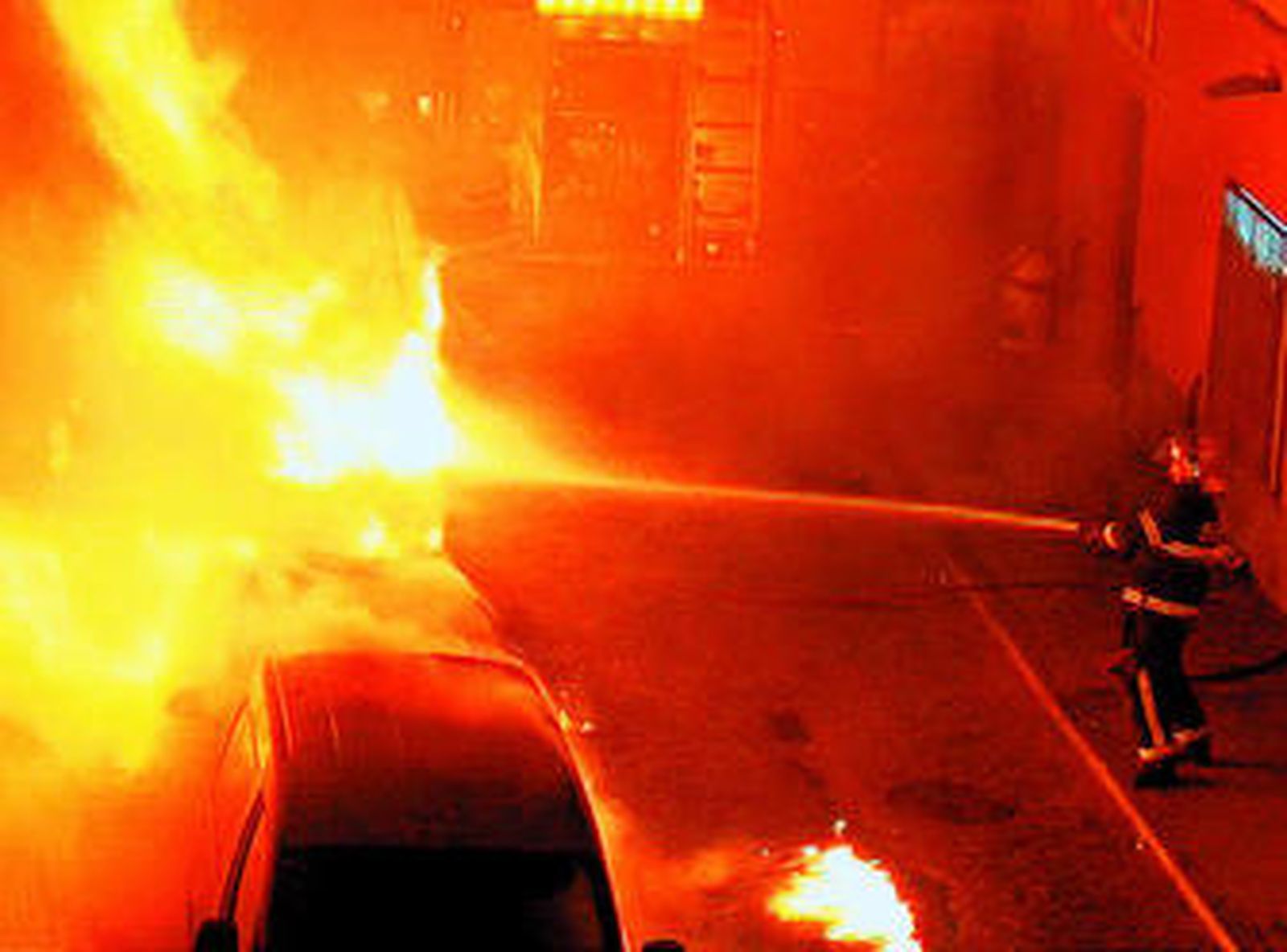 Uno de los bomberos sofocando el incendio, en una imagen tomada por un vecino de la calle.
