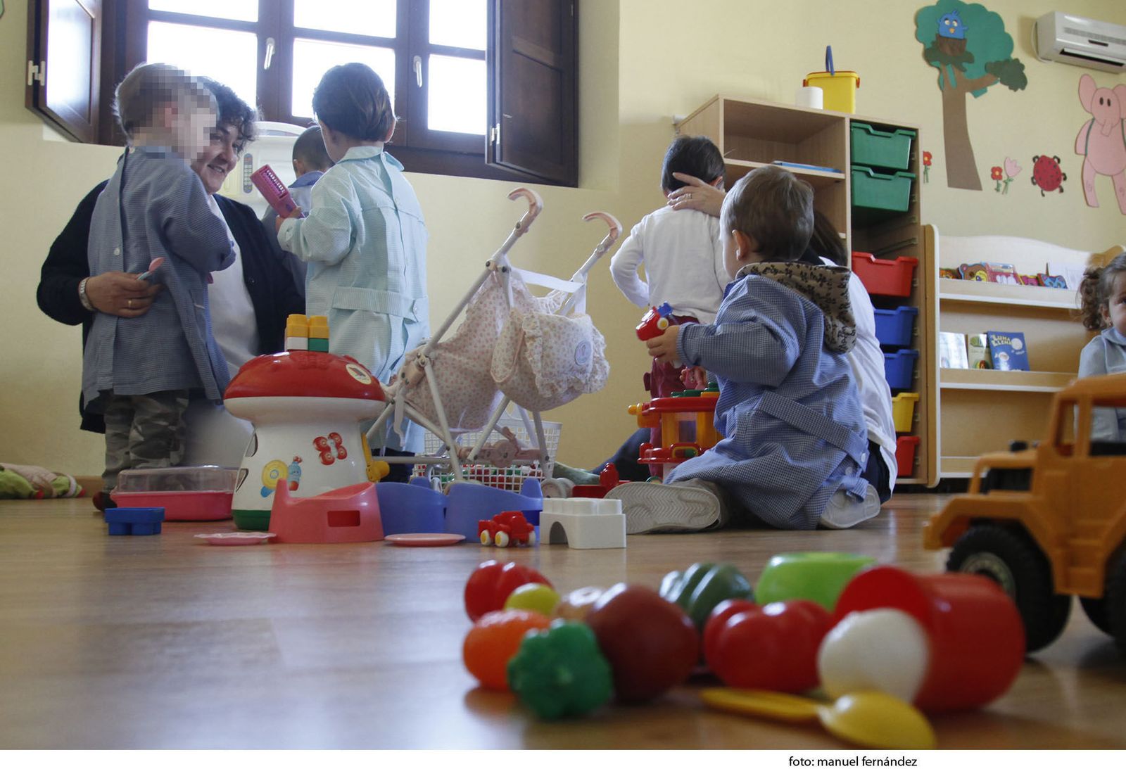Niños con su cuidadora en un centro de educación infantil de primer ciclo.