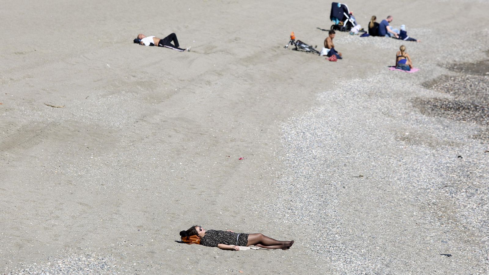 Varias personas tomando el sol en la playa en Málaga.